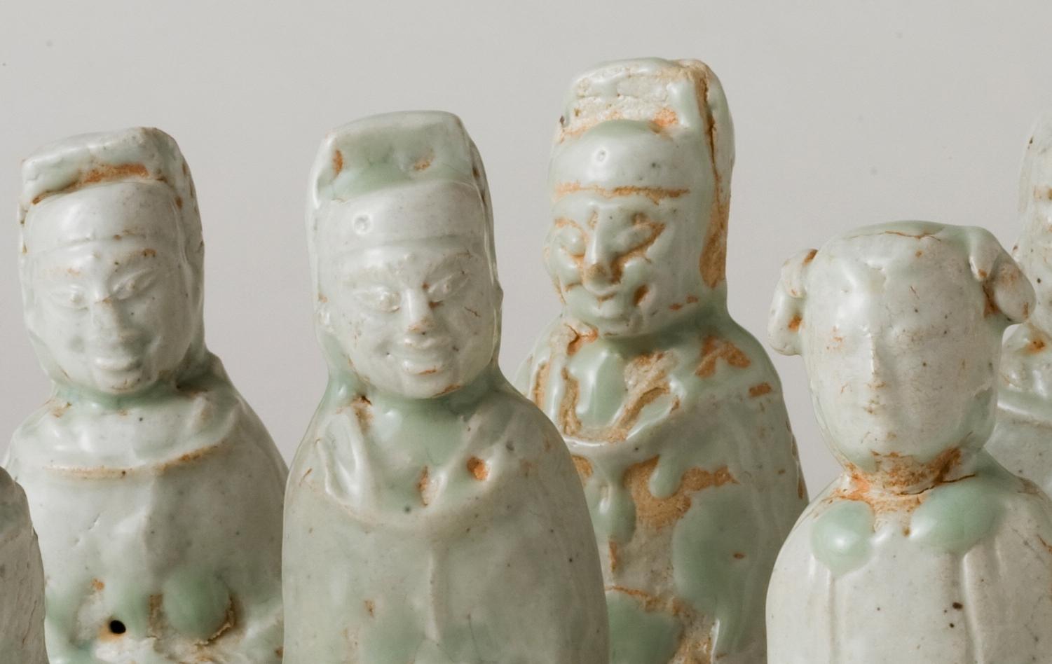 Bei diesem Werk handelt es sich um eine Gruppe von Qingbai (青白磁) Porzellanfiguren, die während der Fünf Dynastien bis zur Nördlichen oder Südlichen Song-Periode (10.-13. Jahrhundert) hergestellt wurden. Auf den weißen Ton wird eine transparente