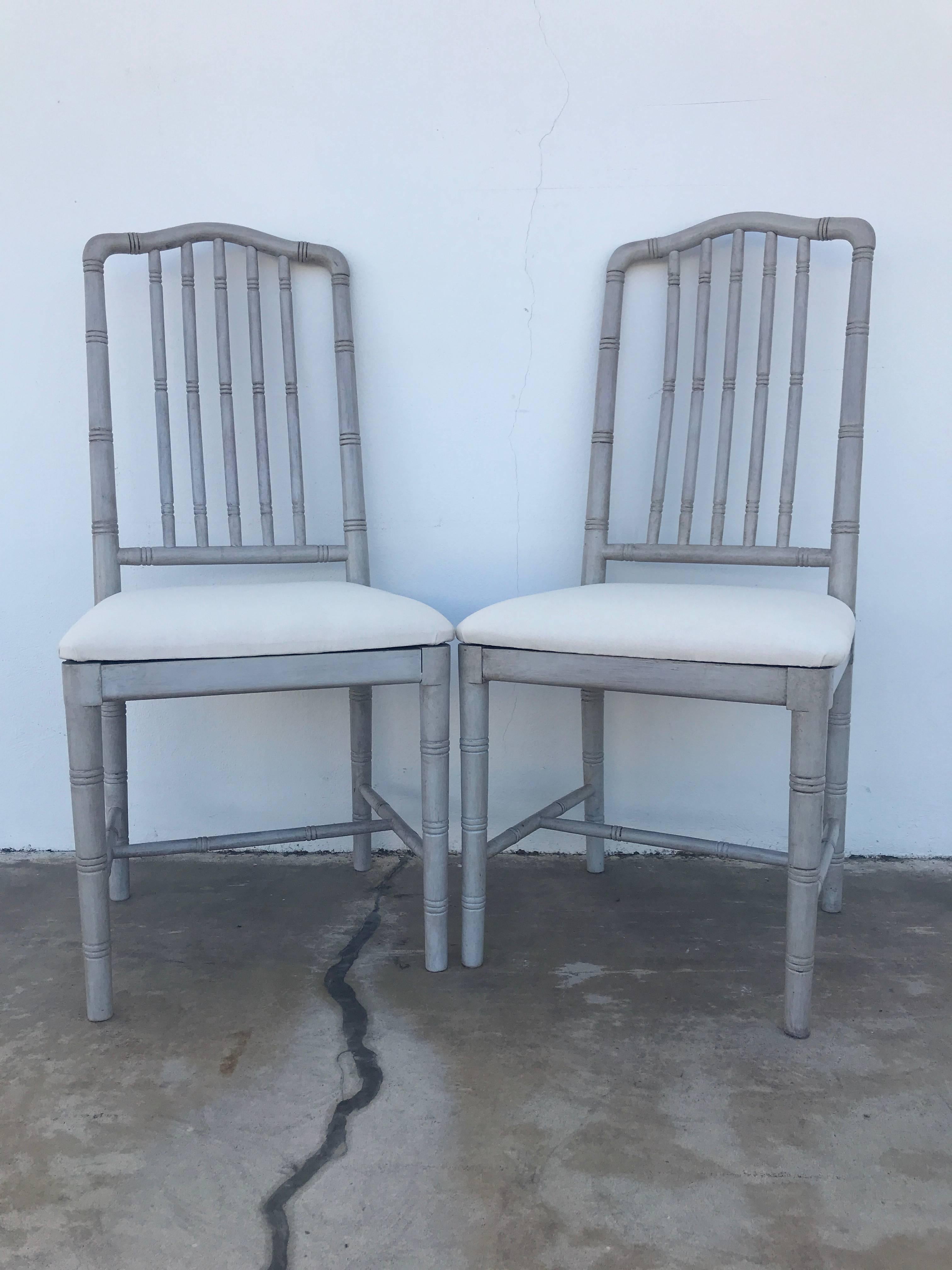 Ten Regency style gray painted faux bamboo dining chairs, each one newly upholstered in muslin.