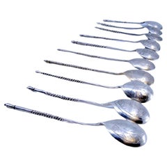 Ten silver dessert spoons with engraved shells and twisted Russian handles