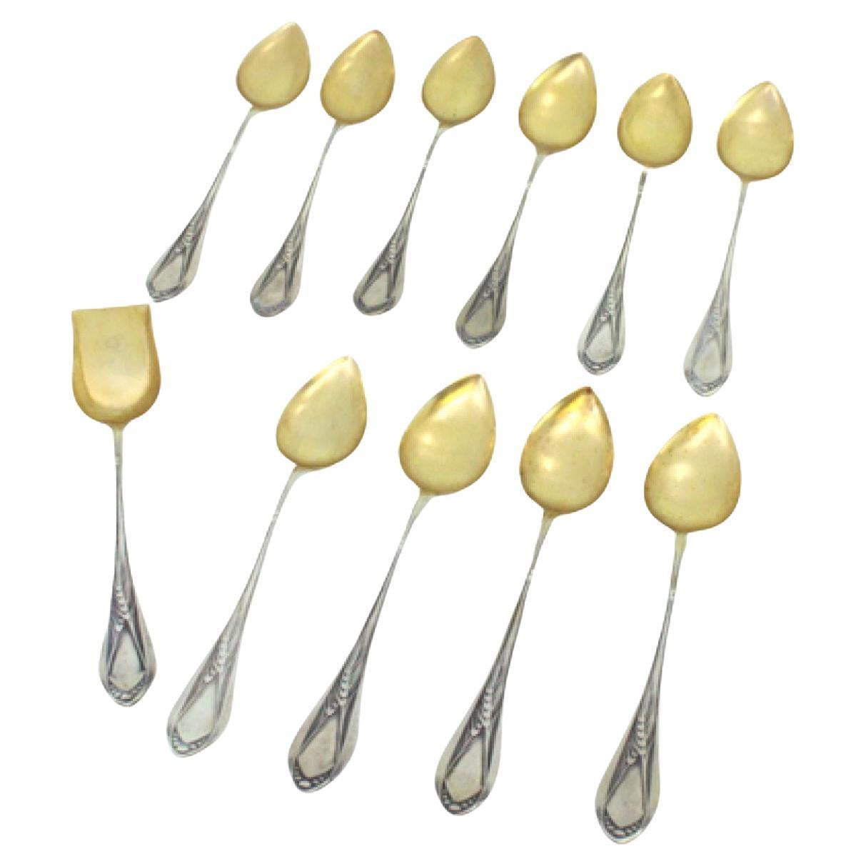Ten silver teaspoons and sugar shovel with gilt shell and handle reliefs