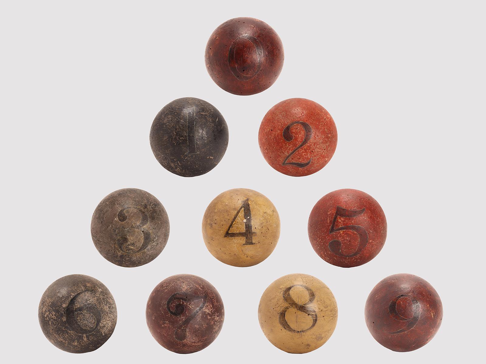 L'énigme du poids de la balle. Il y a 10 boules en bois peint disponibles, de même circonférence, toutes numérotées de 0 à 9, dont 9 ont le même poids et seulement un poids de plus que les autres. Le plus lourd doit être identifié en ne disposant