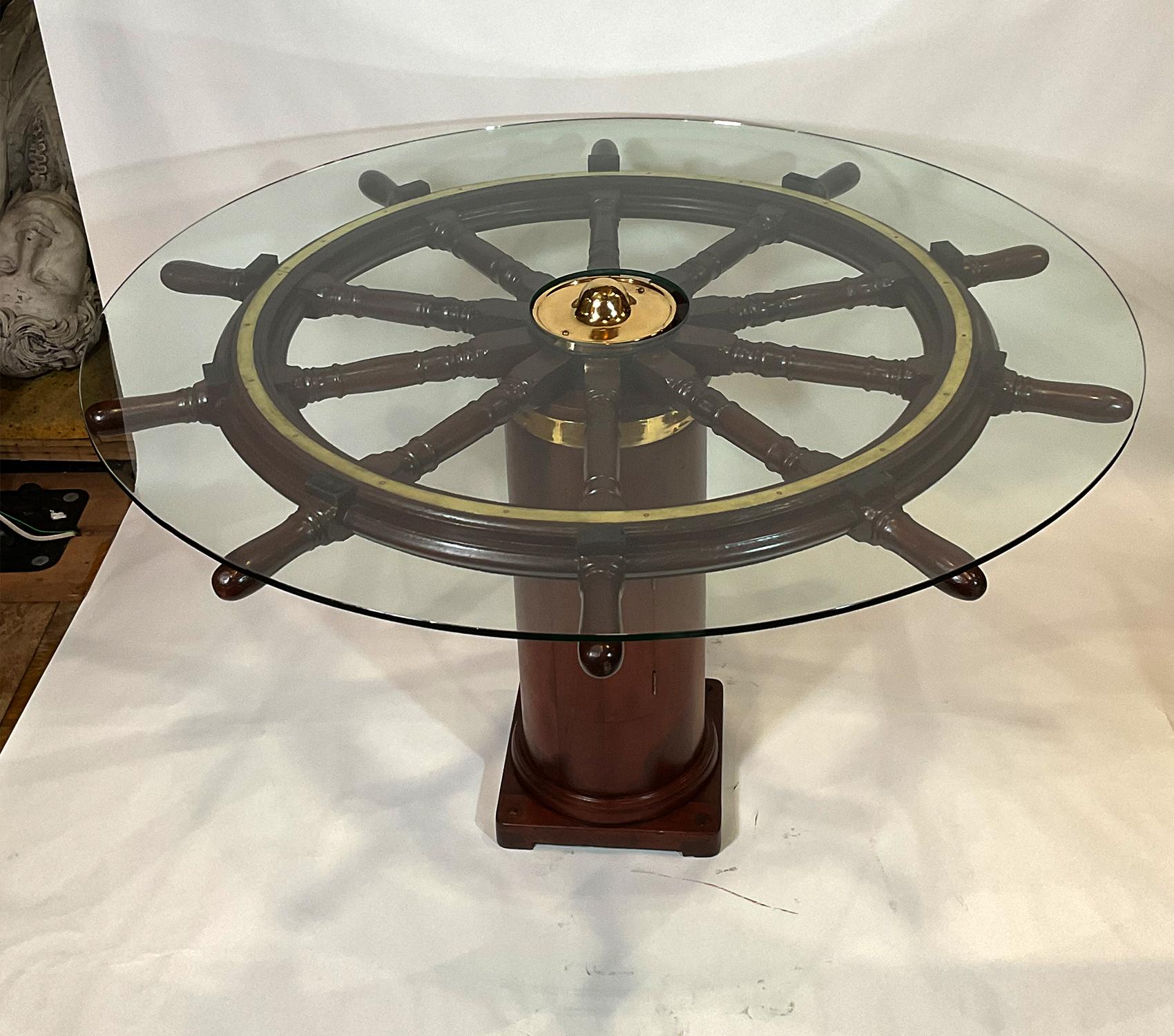Nautical dining table created with an extraordinary antique ships wheel mounted to a ships binnacle base. The rare ships wheel is from the late Nineteenth Century and has been expertly refinished. The binnacle base with hinged door and brass band