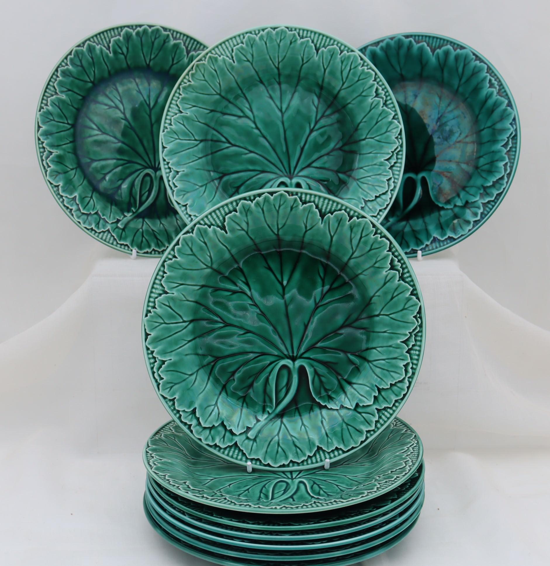 This set of ten Wedgwood Majolica plates all feature a moulded cabbage leaf decoration under a transparent green glaze. The diameter is 200 mm (8 inches) and they stand 25 mm (1 inch) high. They are in very good condition with no cracks or chips,