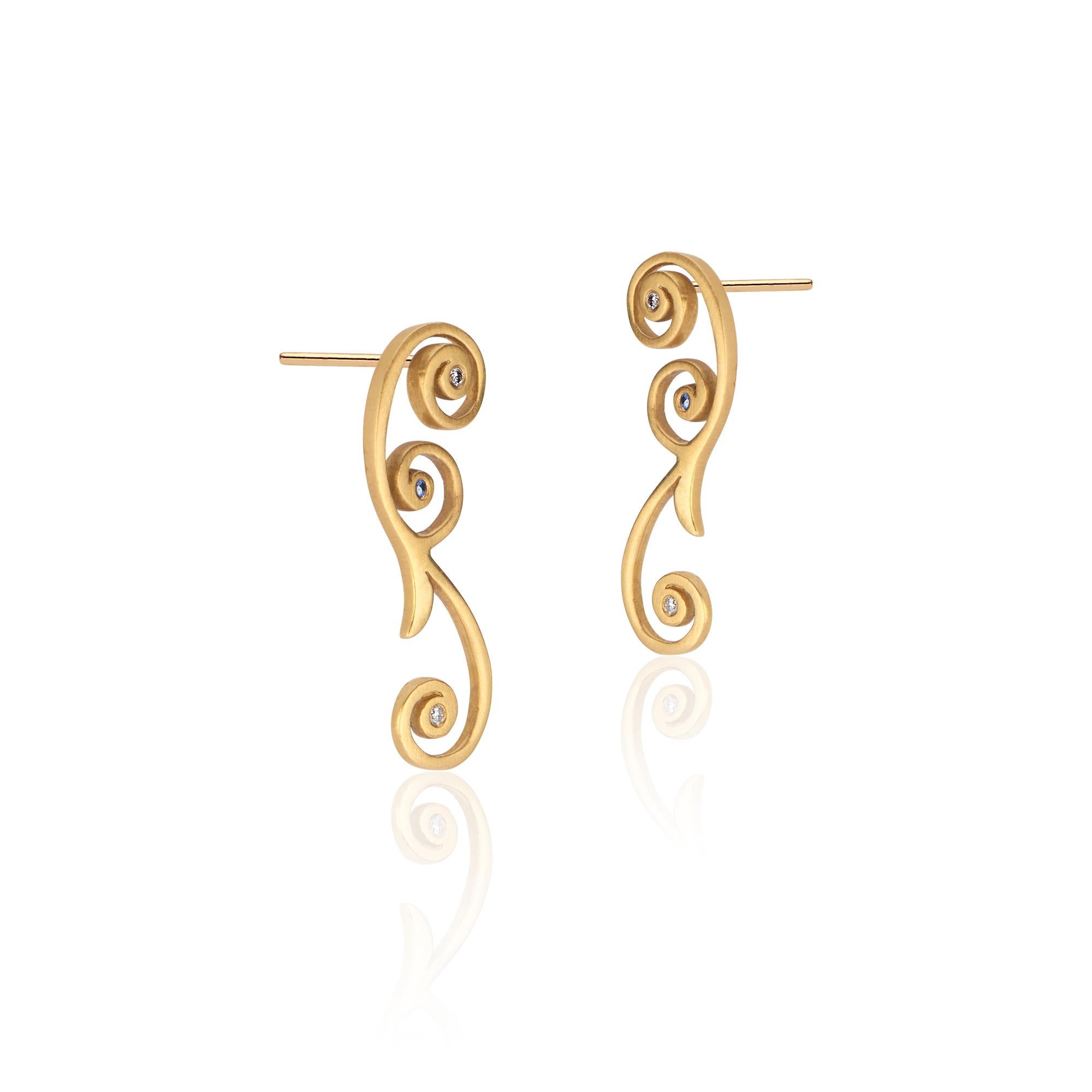 22k gold drop earrings approximately one inch long (25 millimeters), extending down from the ear with a slender tendril curl. Nestled in the heart of the curl of each earring are two 1.2 millimeter diamonds. Blue sapphires provide a surprising