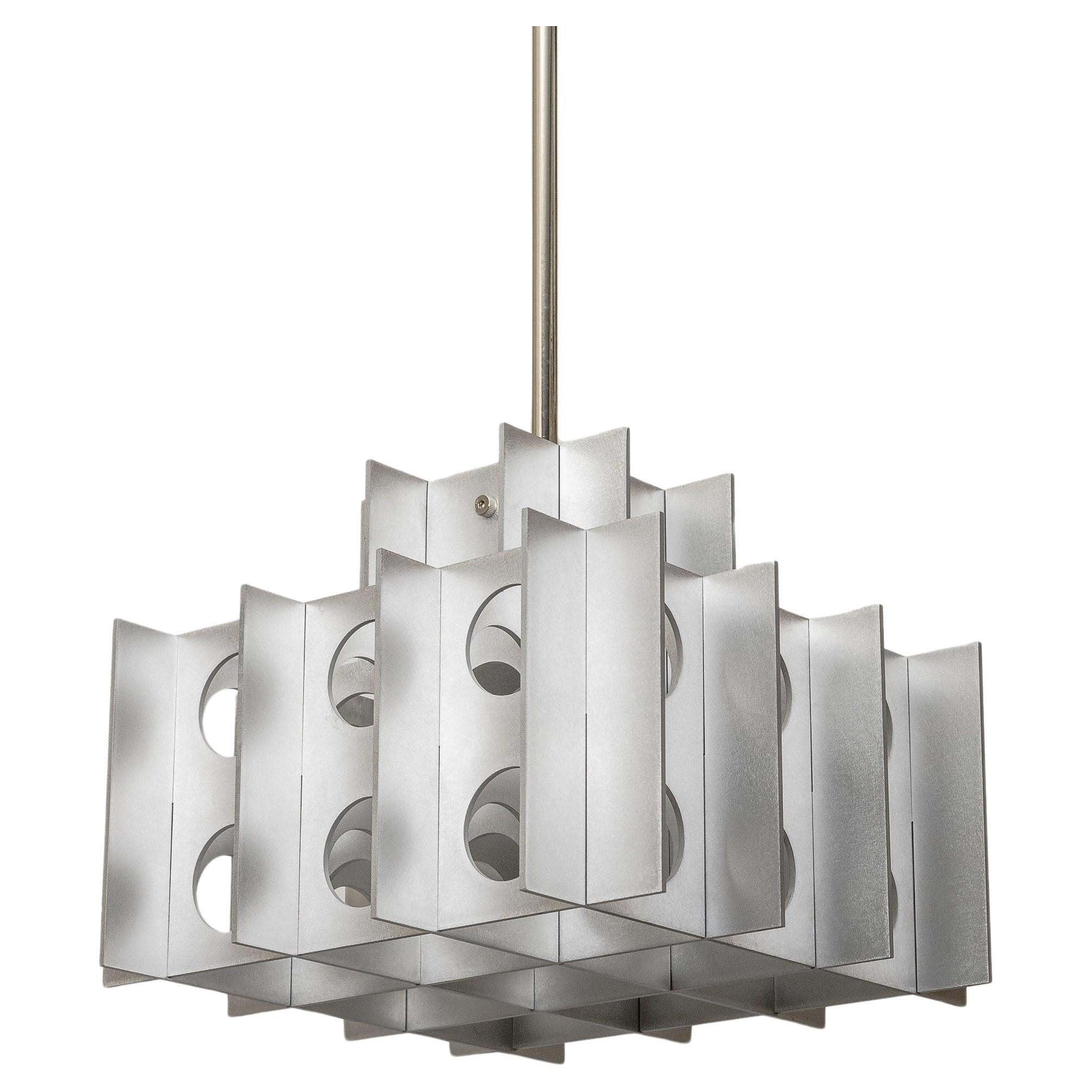 TENFOLD PENDANT 3TA 32inch by Luft Tanaka Studio

Composed of interlocking sheet metal panels, the Tenfold Series is inspired by brutalism and the 1970's architectural style. The light fixture works well as a single fixture over a dining table