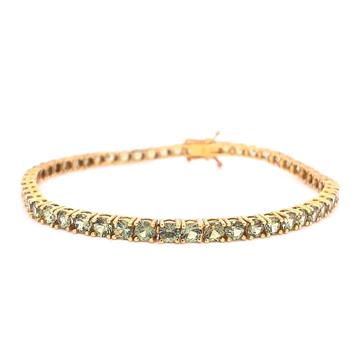 This classic style tennis bracelet features Round Brilliant Cut Natural Green Stones. 
Sparkling and slim, this gemstone tennis-style bracelet complements any attire. Fashioned in Yellow Gold, this 8.0-inch bracelet secures with a tongue and groove