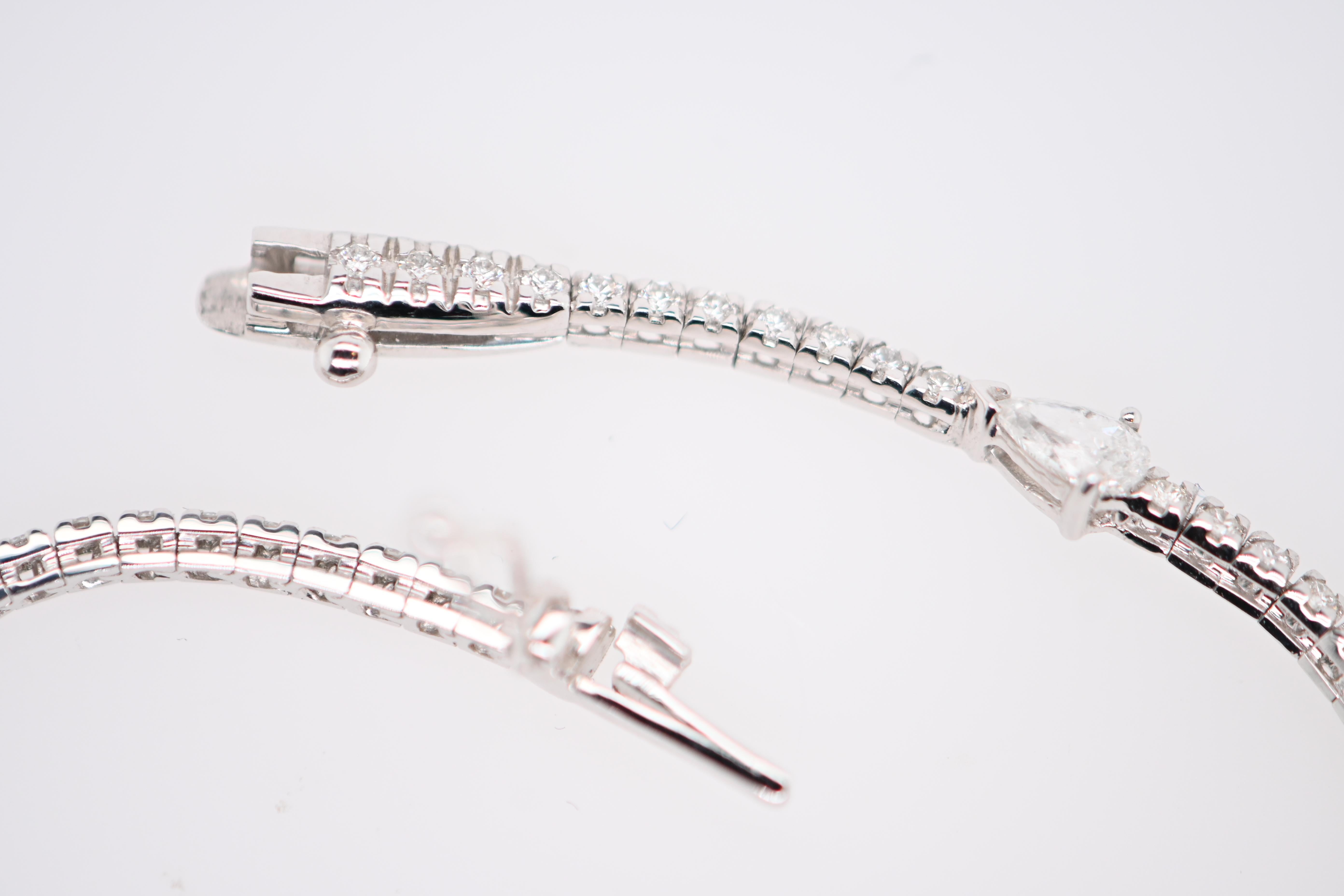 Ein prächtiges Tennisarmband aus Weißgold, besetzt mit schillernden weißen Diamanten und prächtigen birnenförmigen Diamanten. Dieses unglaubliche Juwel ist ein wahres Kunstwerk, das Eleganz, Raffinesse und Brillanz vereint.

Dieses sorgfältig
