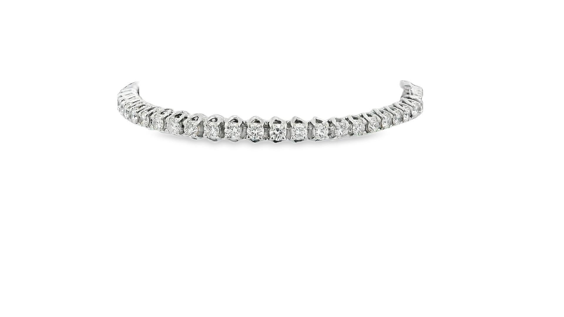 Le bracelet est un bijou raffiné qui présente avec élégance une ligne continue de diamants de taille ronde. Ces diamants se distinguent par leur couleur blanche immaculée et leur grande clarté, classée VS1, qui rehausse leur brillance générale.