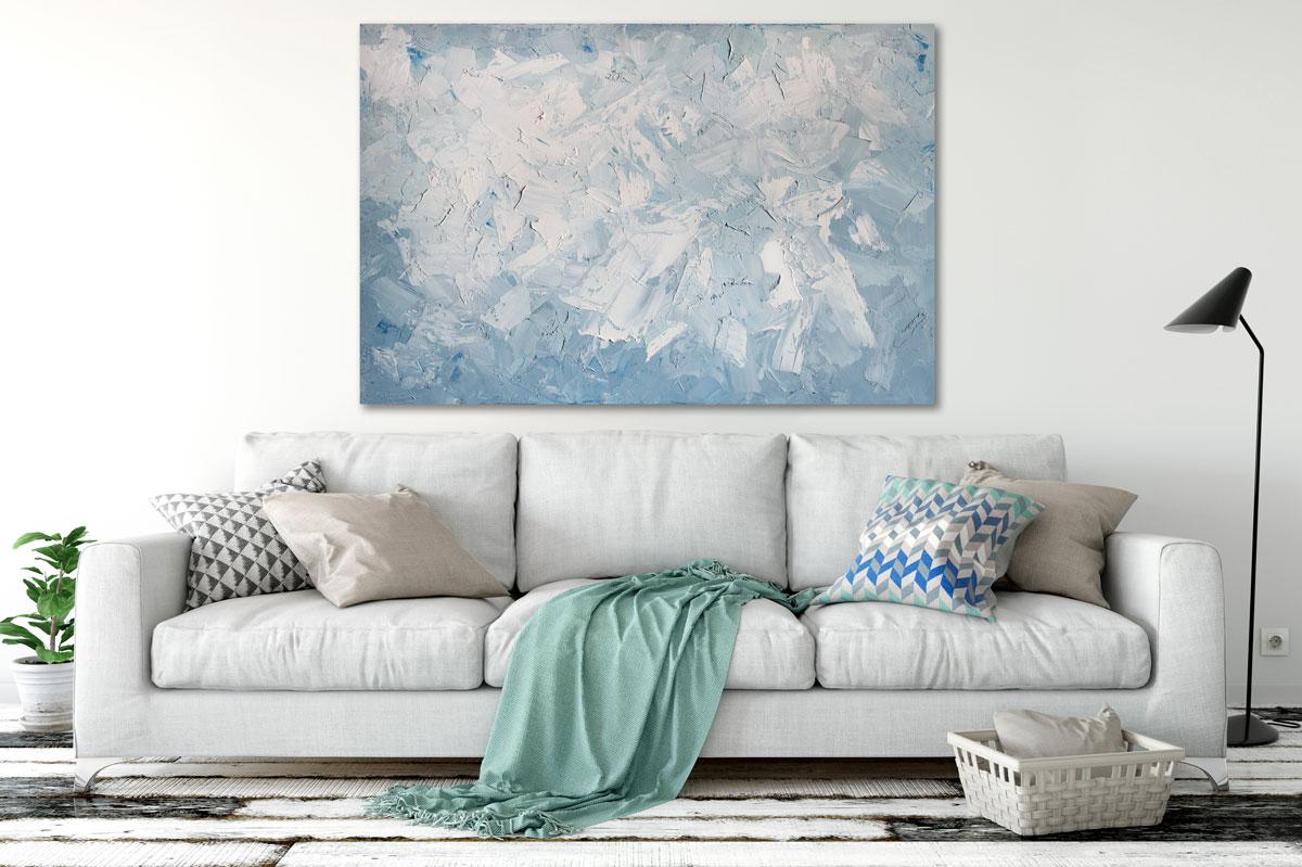 This large-scale, abstract statement painting is made with oil paint on gallery wrapped canvas. Thick strokes of white paint are layered on top of muted, light blue and grey under layers. Small dabs of pure blue can be found sporadically throughout