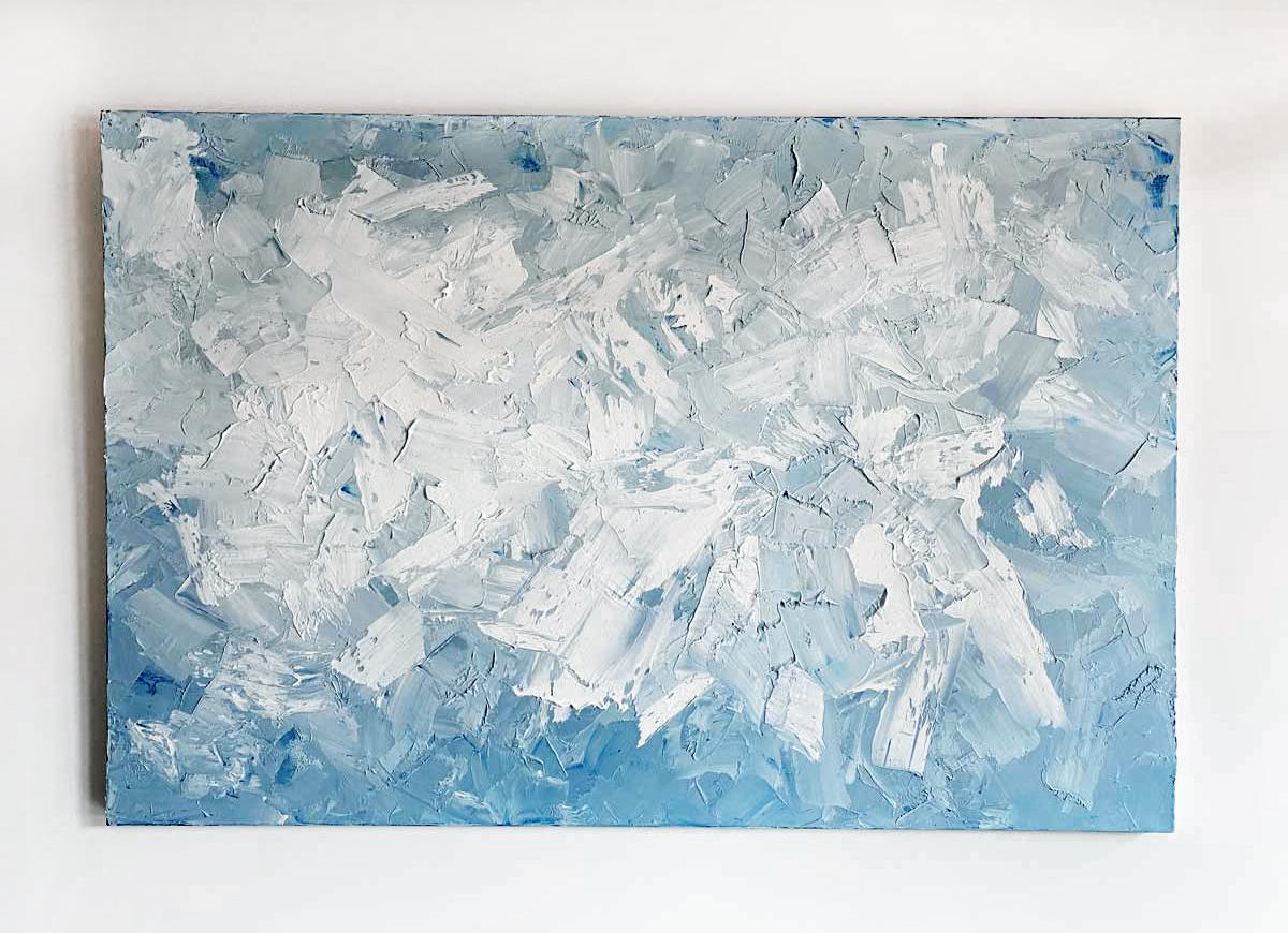 This large-scale, abstract statement painting is made with oil paint on gallery wrapped canvas. Thick strokes of white paint are layered on top of muted, light blue and grey under layers. Small dabs of pure blue can be found sporadically throughout