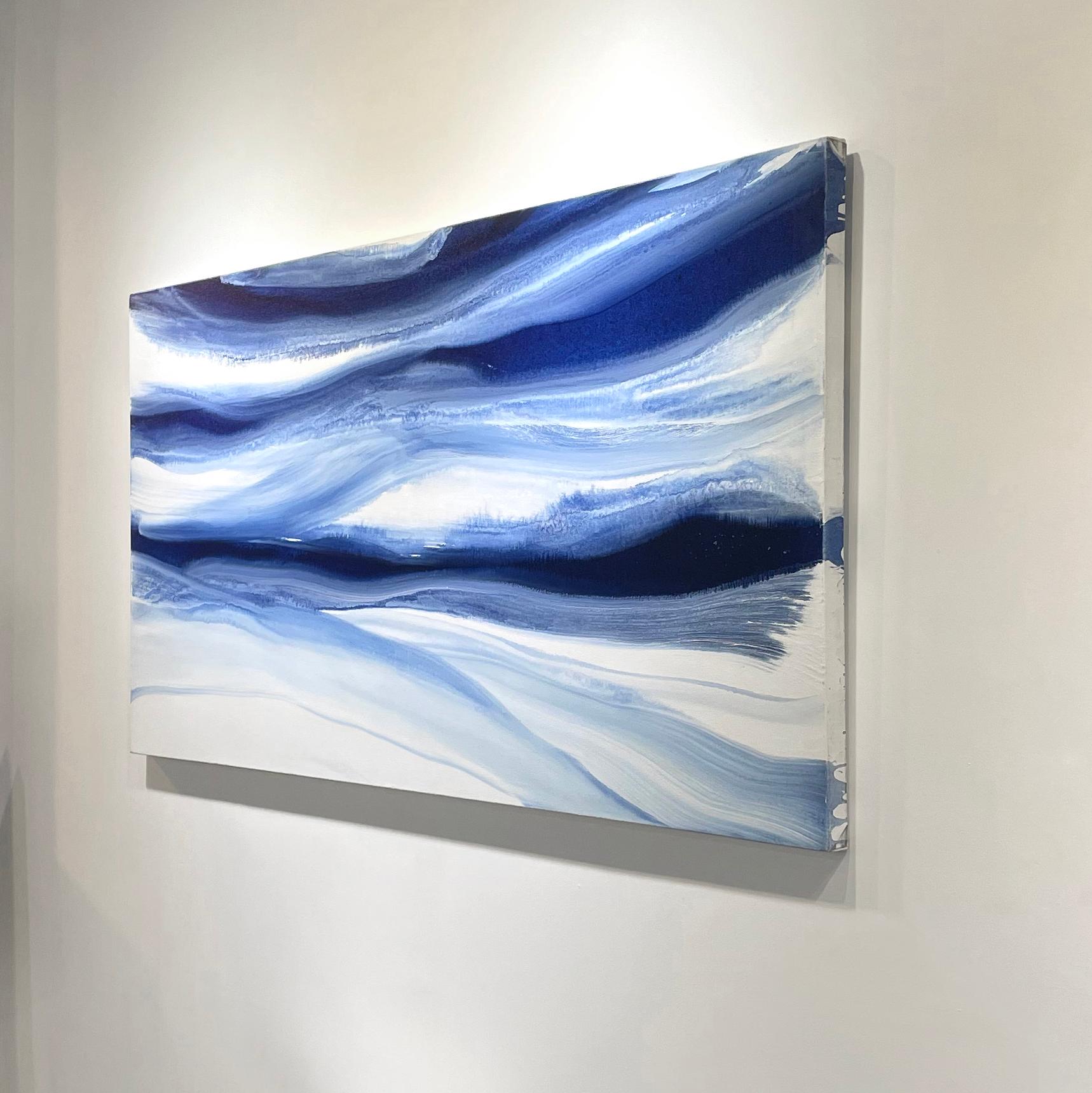 This large-scale abstract painting by Teodora Guererra features a blue and white palette. The artist blends a wash of deep blue tones to create a flowing composition, with ribbons of blue extending horizontally across the canvas. The painting is