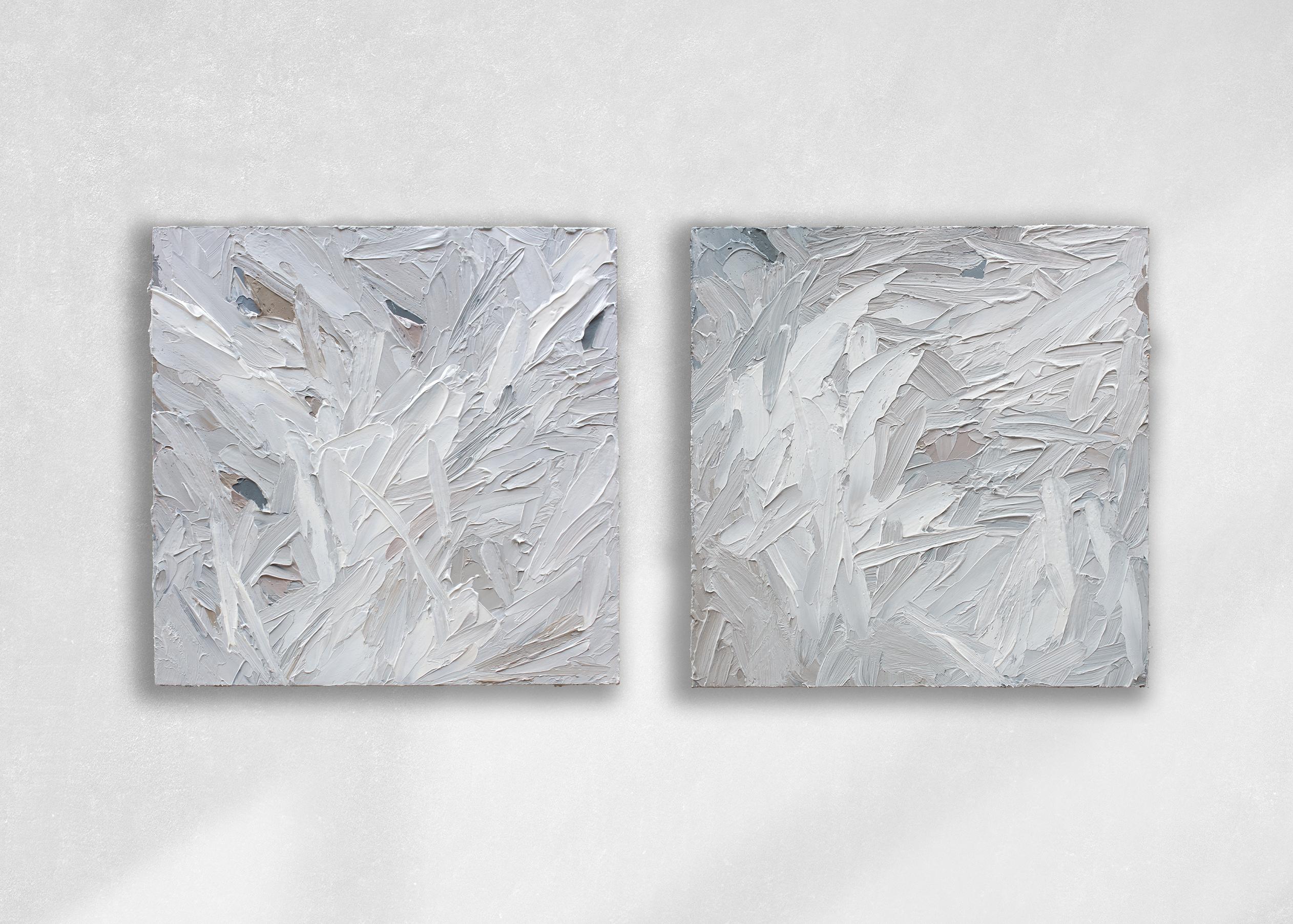 This pair of textured abstract paintings by Teodora Guererra features a light, greyscale palette with subtle warm accents throughout the composition. The artist layers thick strokes of paint using a palette knife over board, creating an abstract