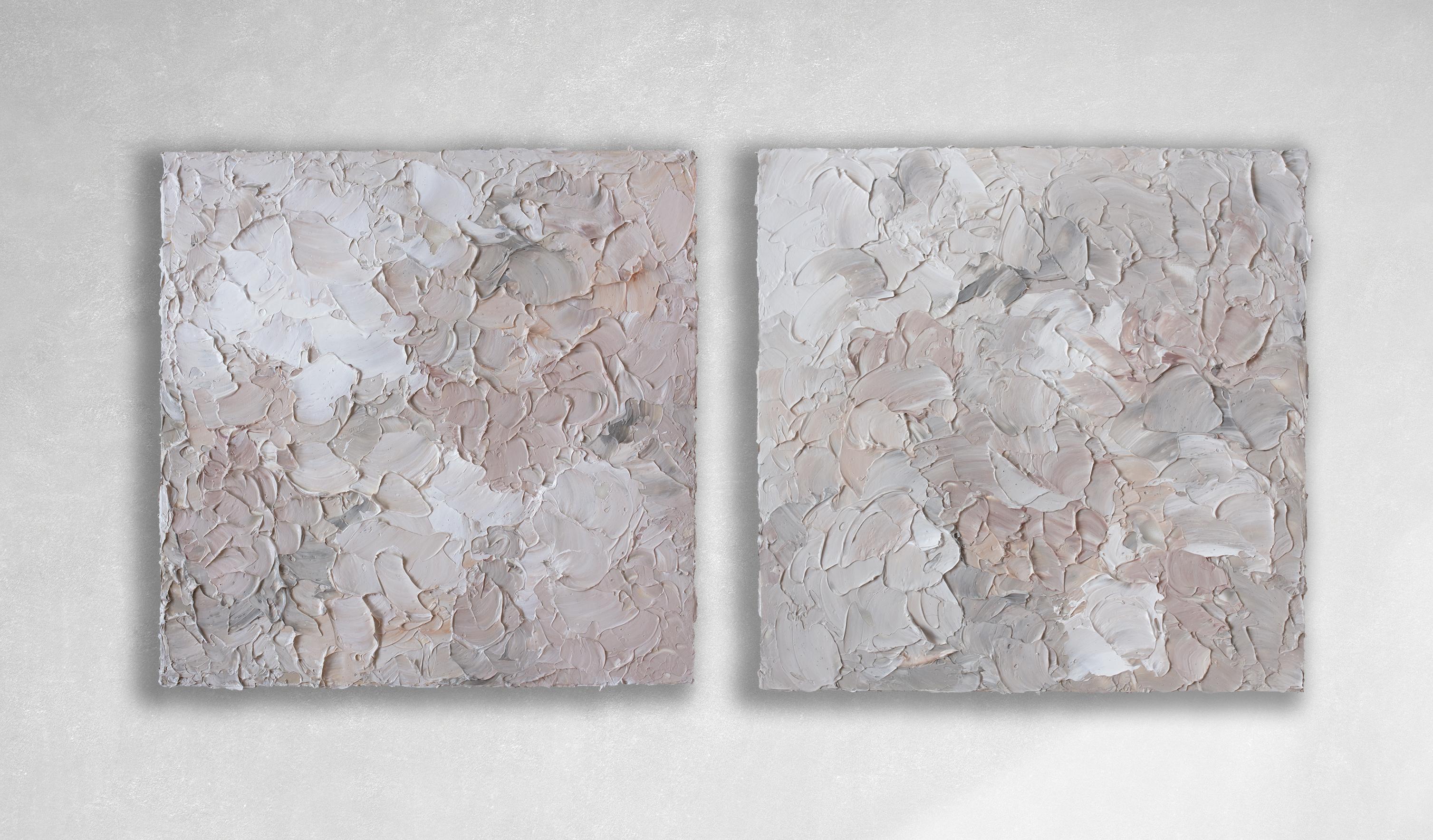 This pair of textured abstract paintings by Teodora Guererra features a warm neutral palette with varying tones of muted blush and coral with white and warm grey. The artist uses a palette knife to layer thick applications of paint on the panels, a