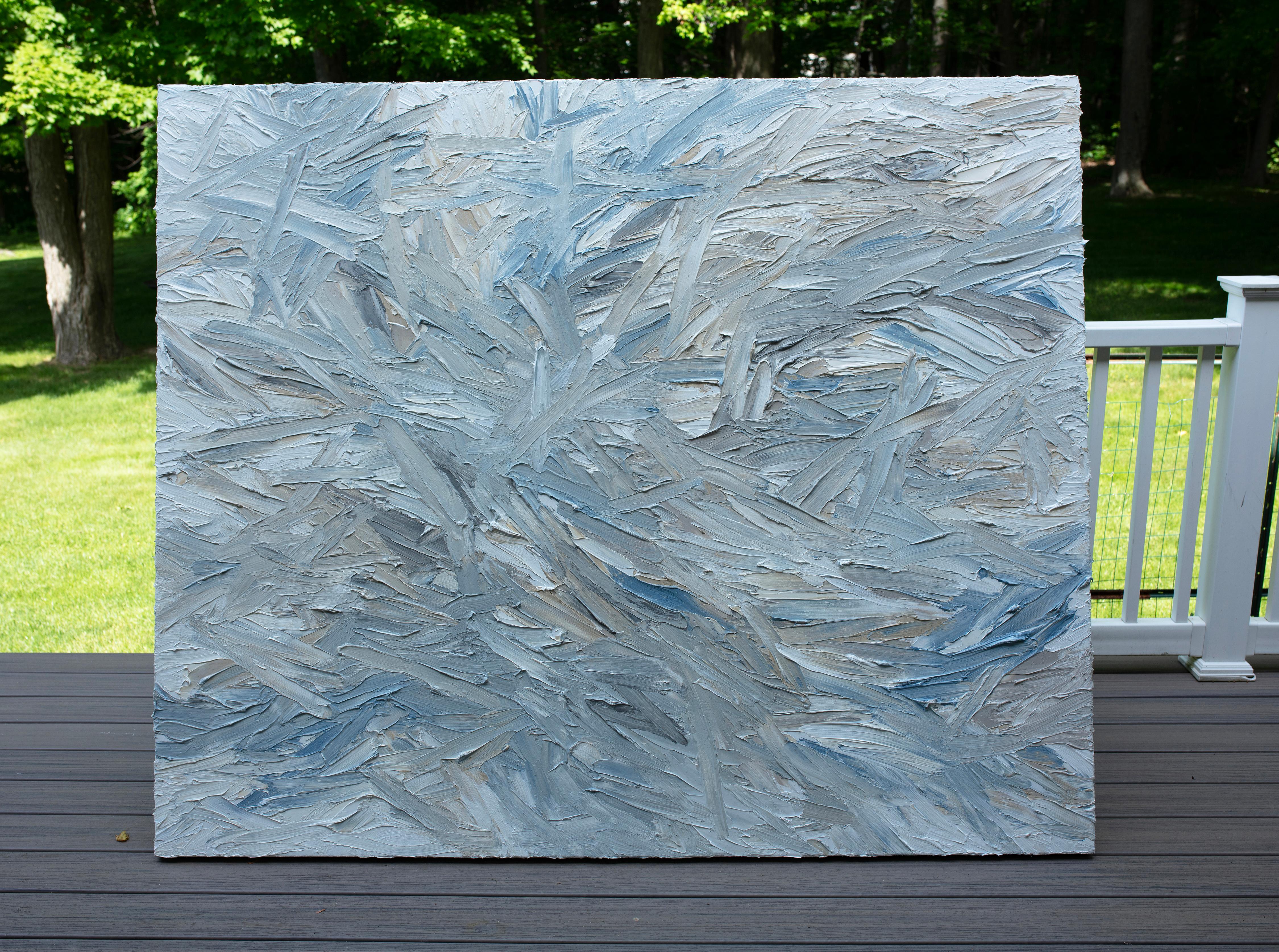 Cette peinture abstraite de Teodora Guererra présente une palette dynamique de bleus doux et glacés, de gris argentés et de subtiles touches de beige superposés dans un réseau complexe de coups de couteau épais. L'artiste effectue des mouvements
