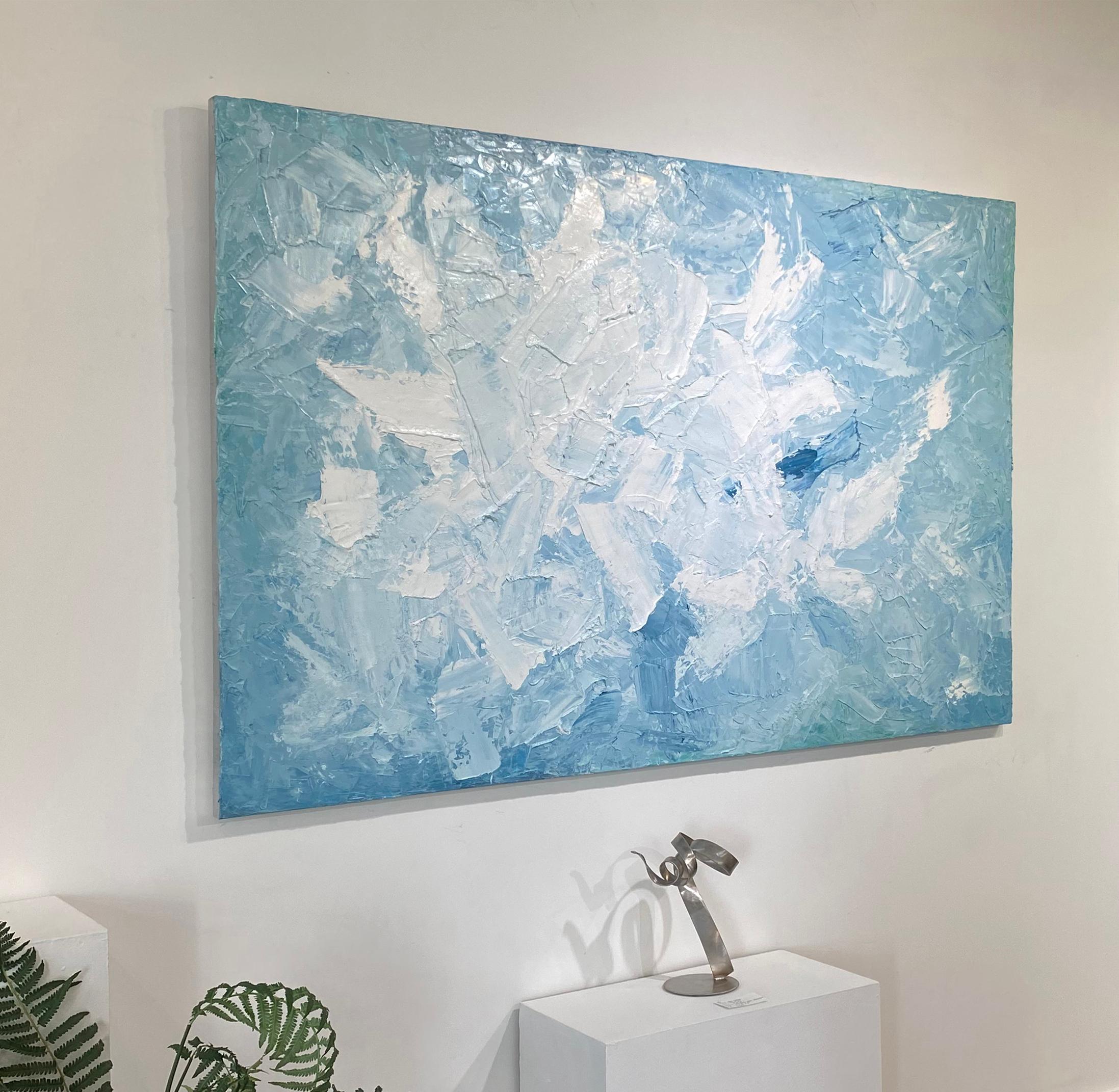 This large-scale, abstract statement painting is made with oil paint on gallery wrapped canvas. Thick strokes of white paint are layered on top of sky blue and muted teal under layers. Spots of pure blue can be found sporadically throughout the