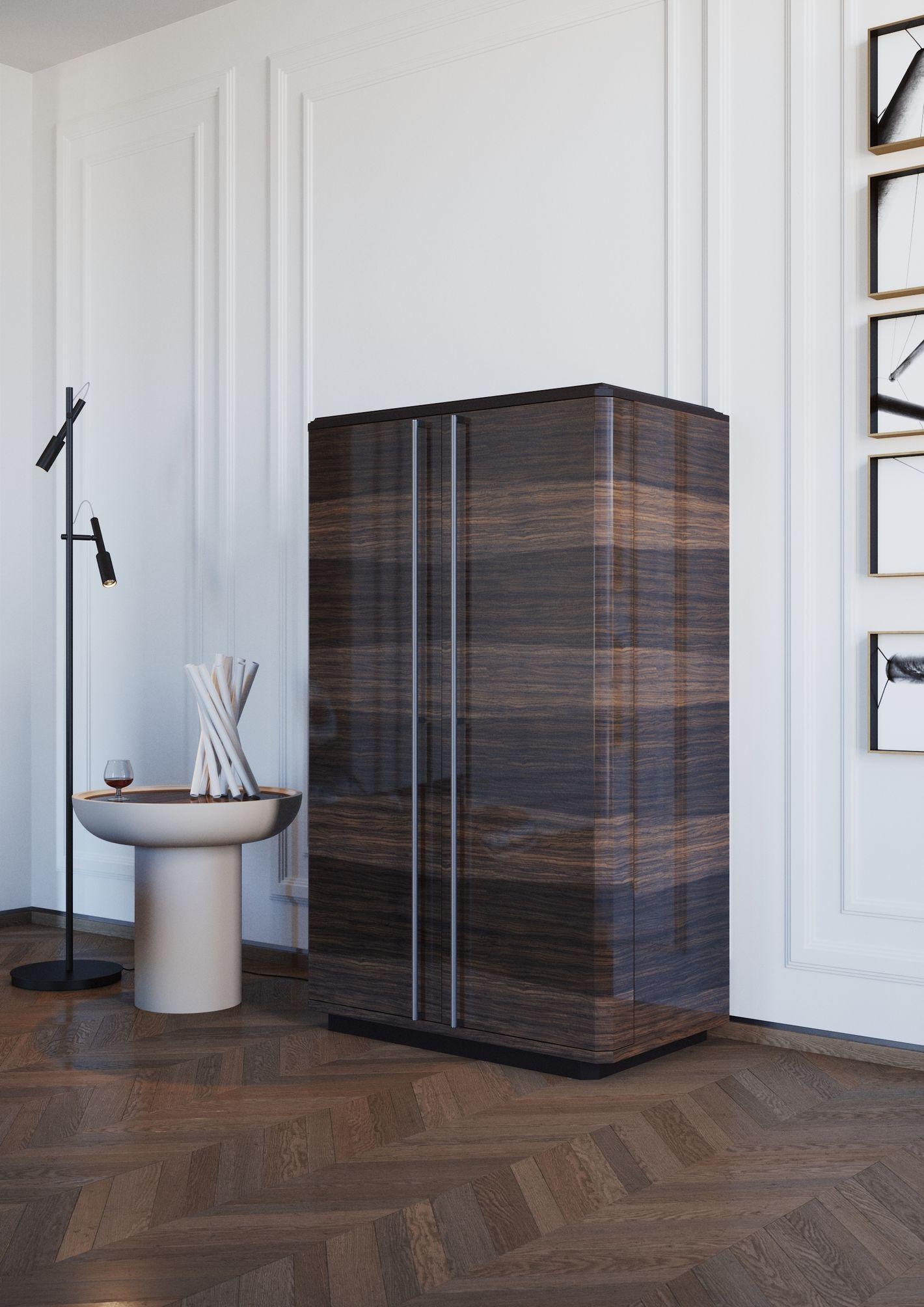 Joyau d'ébénisterie à l'allure contemporaine raffinée, ce meuble bar synthétise sans effort rigueur et luxe. La structure en bois d'eucalyptus fumé brillant révèle un intérieur riche où un miroir gravé sert de toile de fond aux étagères en verre et