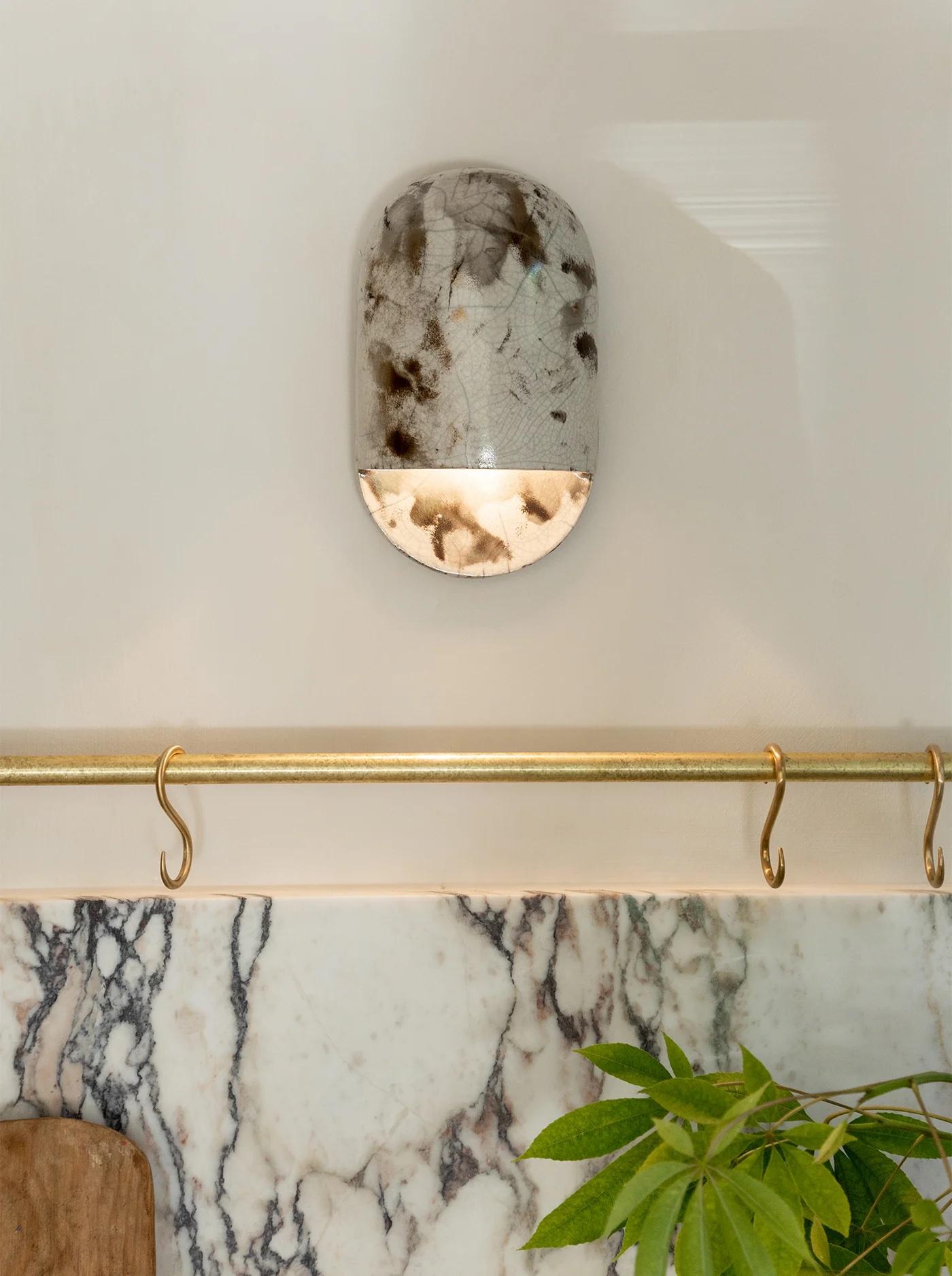 El aplique Tera es el aplique de pared característico de Ceramicah. Su tamaño compacto y sus proporciones limpias la hacen perfecta para cualquier espacio. El exclusivo acabado craquelado iridiscente se consigue mediante un proceso de cocción