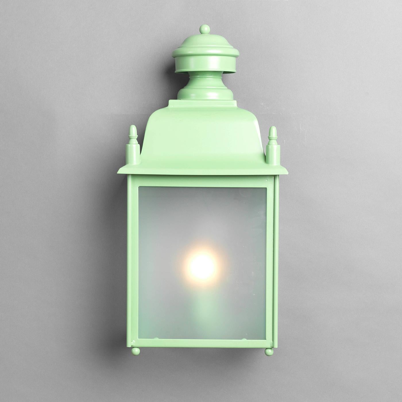 This simple wall lantern topped with an ornate domed decoration will be an eye-catching accent to add on a front porch or in multiples to illuminate an outdoor dinner on a terrace. The stainless steel frame was treated with zinc and varnished with