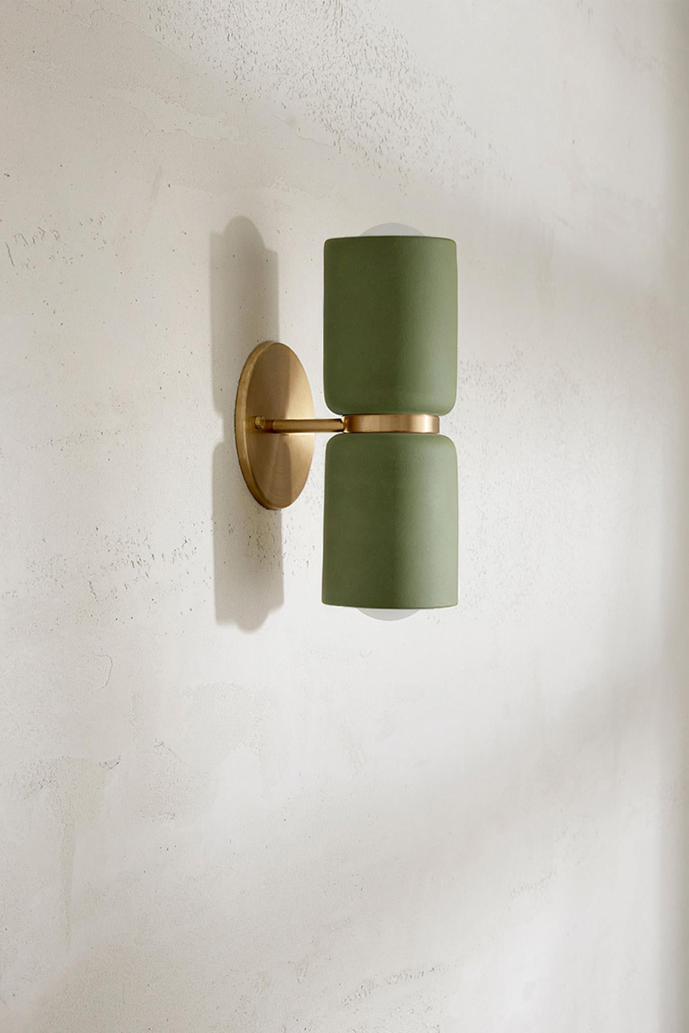 The Terra 2 Wall Light features two slip-cast lamp holders with unique brass, brushed black or white satin detailing. A duo of ceramic cylinders stack together to form a bi-directional wall light suitable for both residential and commercial interior