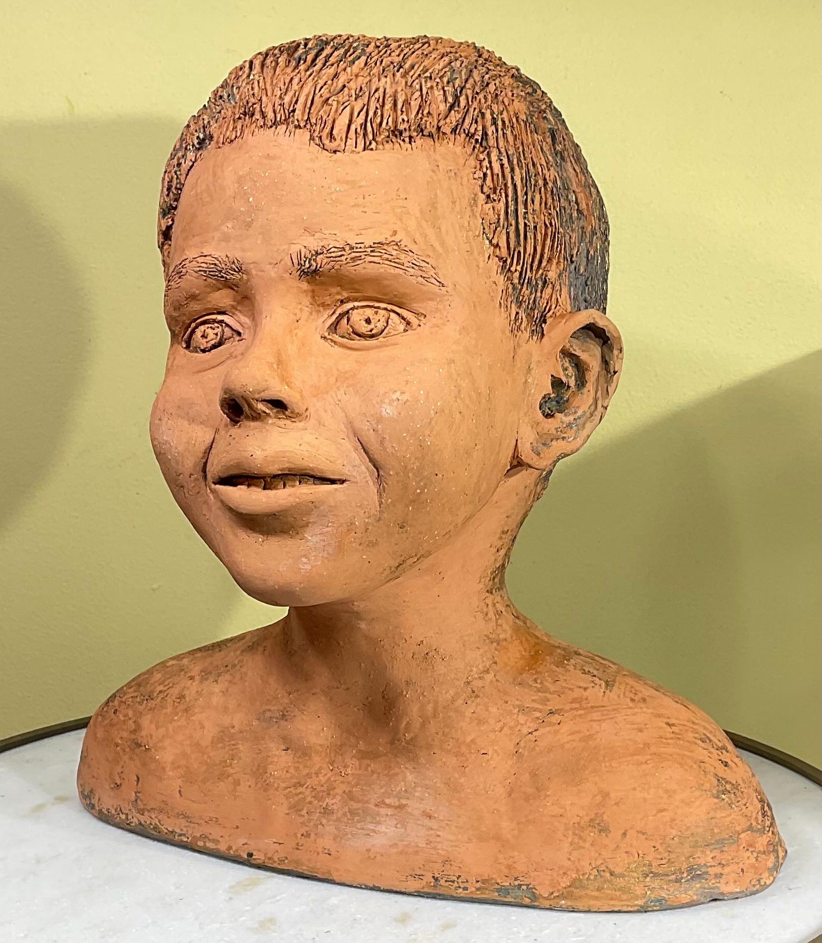 Intriguing bust of a young kid made of rustic terra-cotta, 
 great smile, innocent expression, looking forward.
Beautiful object of art from any angle.
Signed and dated MD 3/91
If anybody know anything about who is the artist please let me