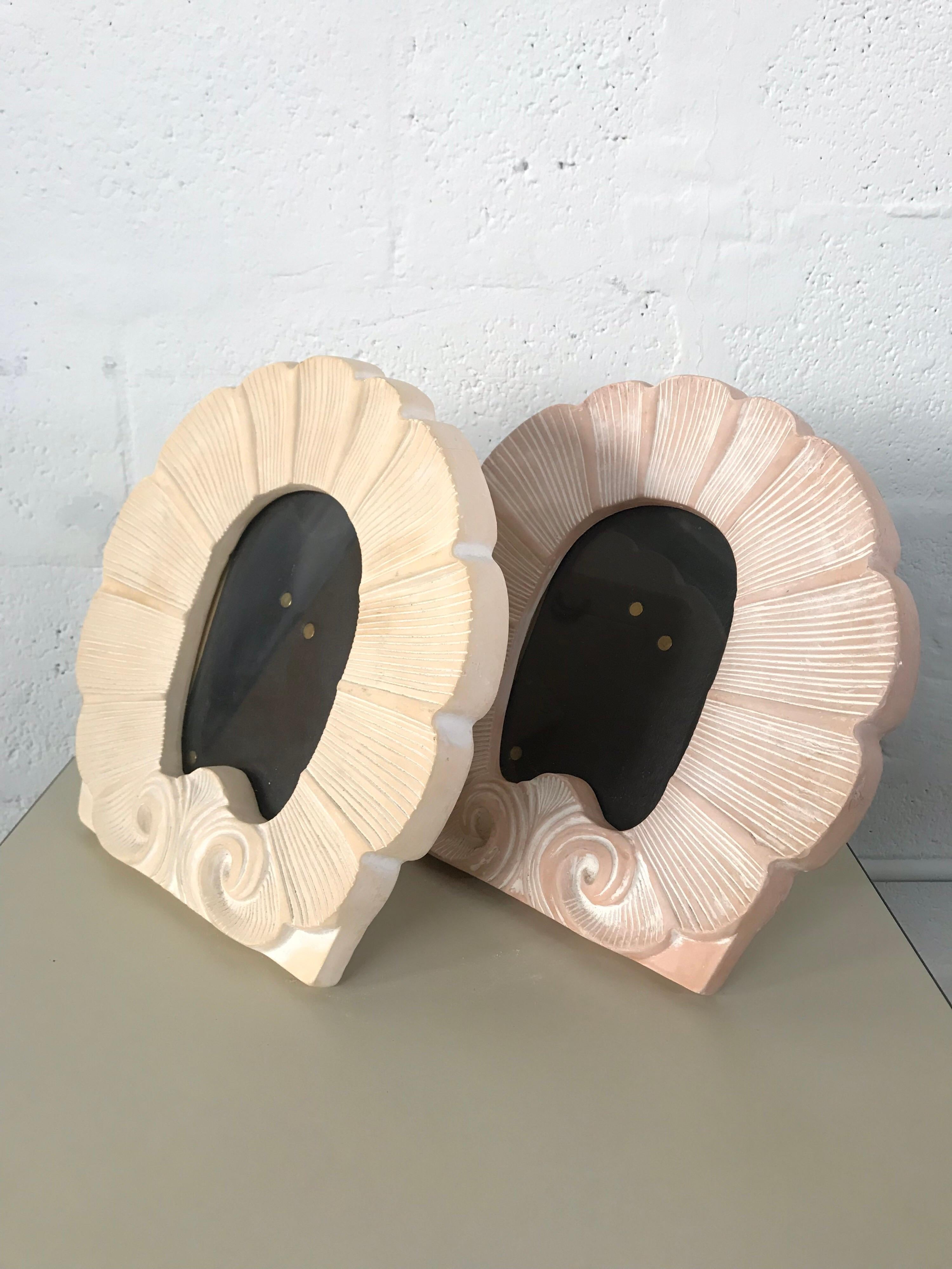 Shell motif photo or picture frame rendered in terra cotta ceramic, in either pink or buff finish.