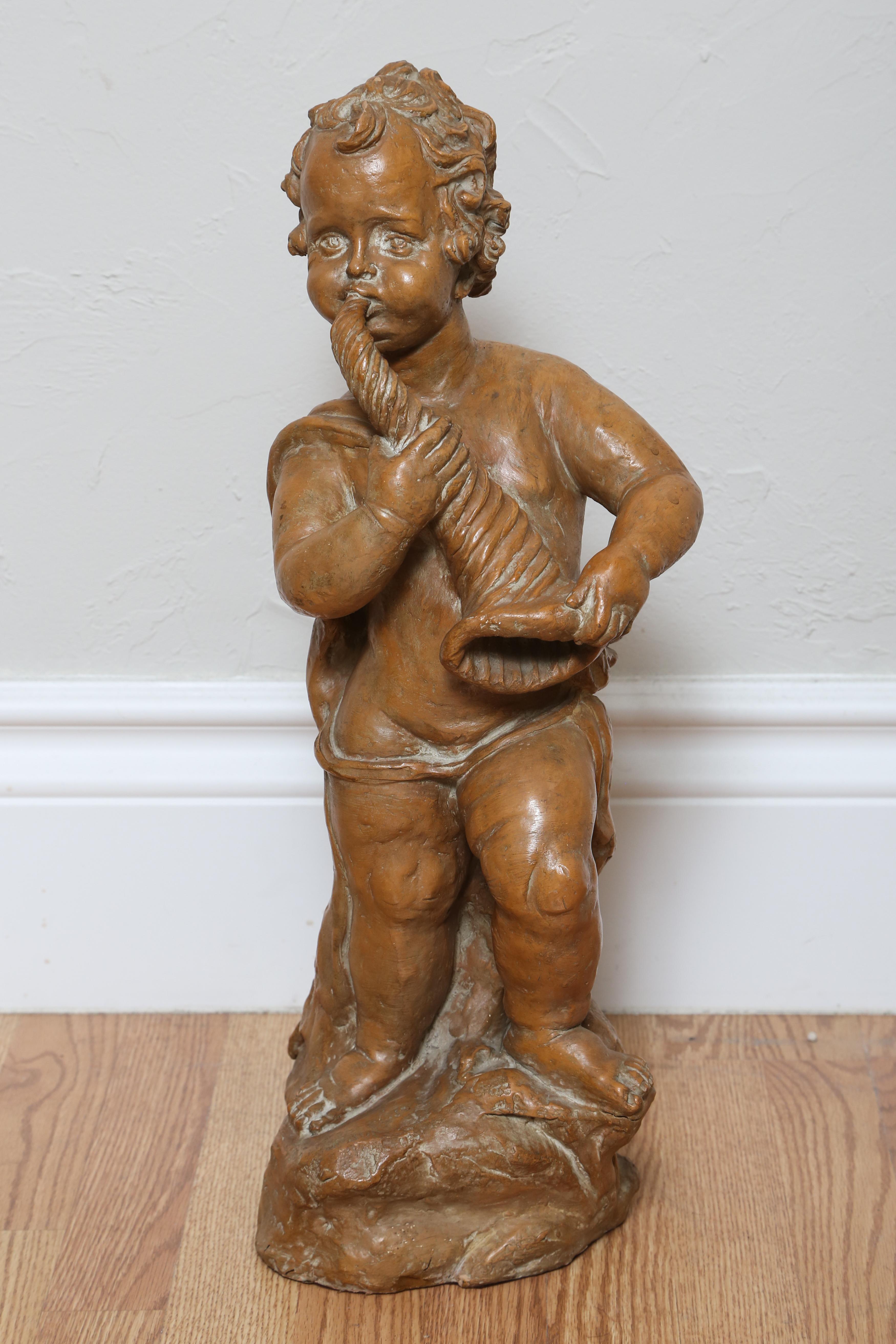 Delightful terra cotta cherub playing Horn. Made in France in the late 19th century.