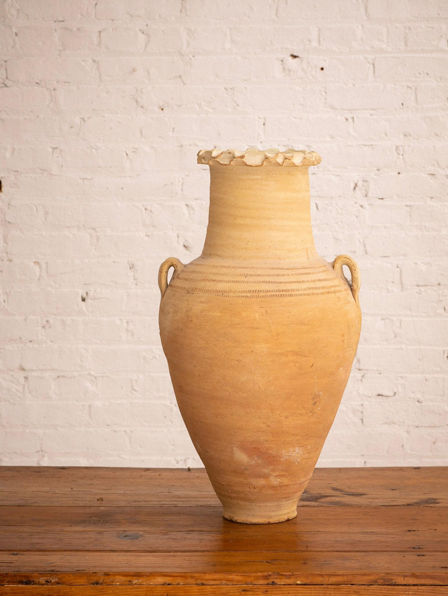 A mid-sized hand thrown terra cotta vessel with natural matte finish. Classic amphora shape with decorative ruffle neck and thatched stripe detail.