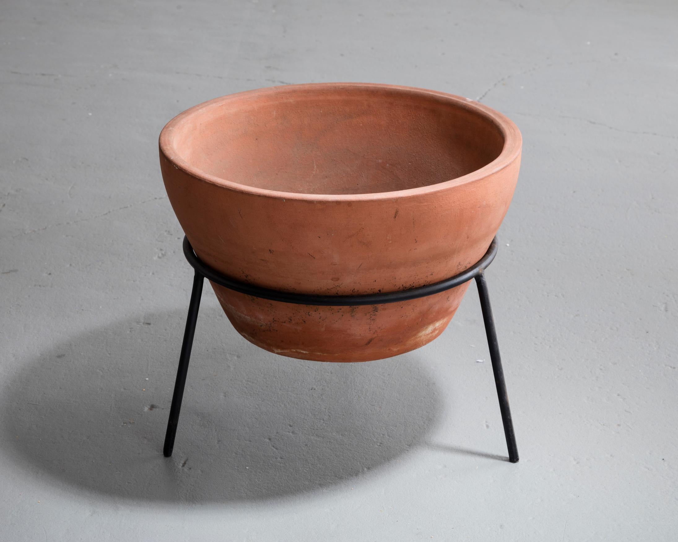 Terra cotta vessel on an iron base. Designed by John Follis for Architectural Pottery, Los Angeles, California, circa 1955.