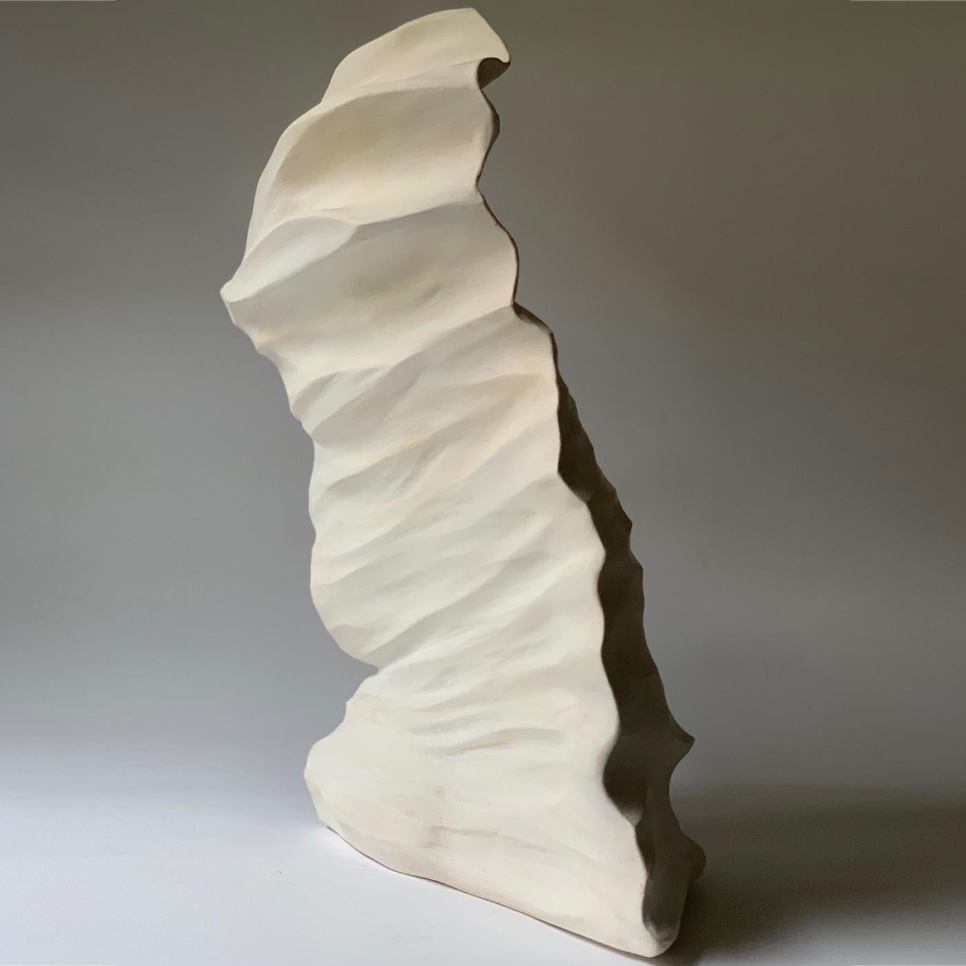 Part of a series based on emerged earth, on telluric movements, and the consequent creation of new shapes, this extraordinary sculpture is handmade of painted and coated earthenware, marked by delicate shades of yellow and pink, exuding a warm and