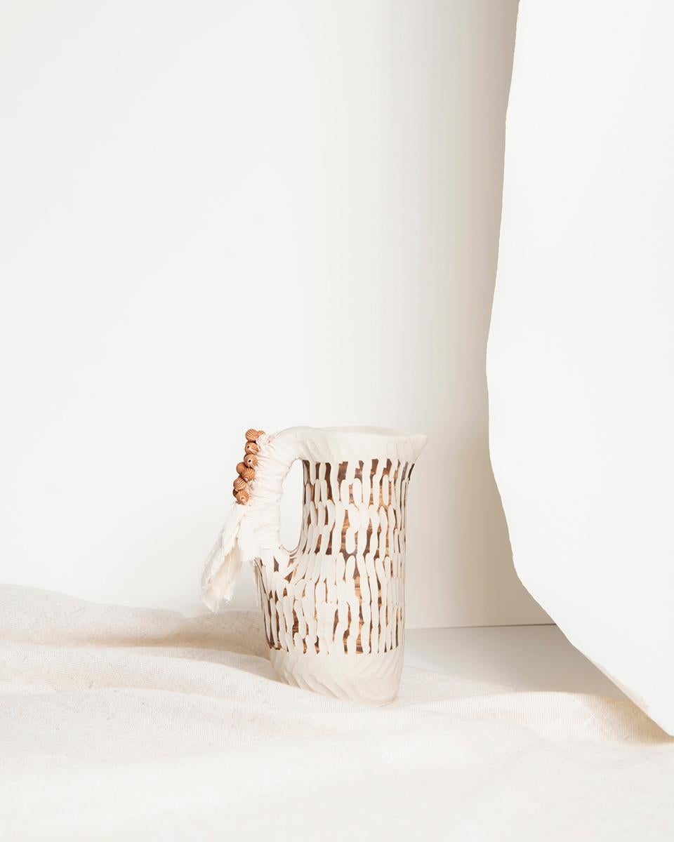 A handmade jug to display in your home
For a rustic, natural touch of European flair, check out this Terra Handmade Ceramic Jug! Brown, white, and adorned with beads and cotton thread details, it's a small and cute addition to your home decor.