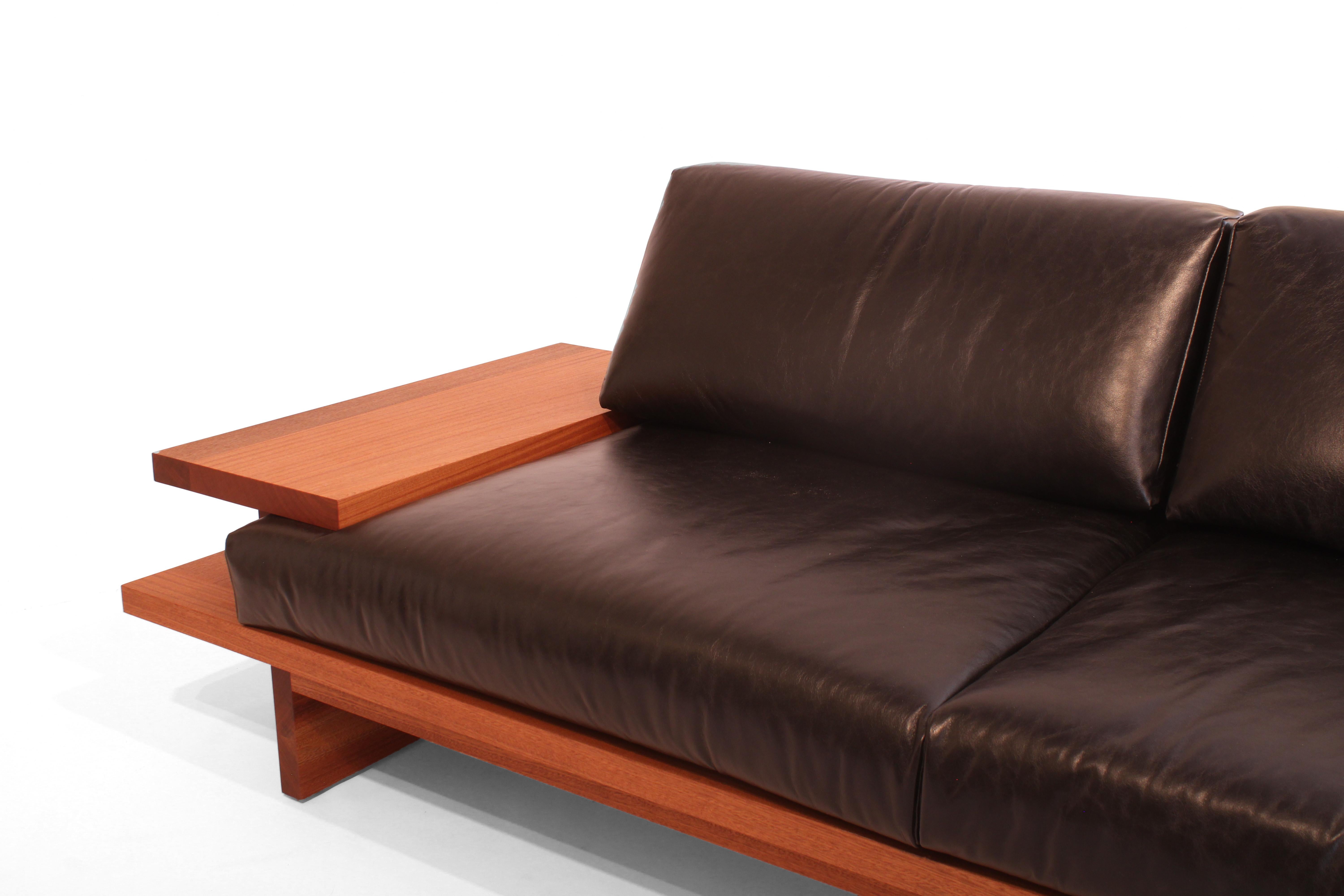 An all solid wood sofa with leather upholstery and integrated side tables made by American designer and maker, Greg Palombo. Like all pieces from Greg Palombo, this sofa was designed to be timeless and built to last generations. The wood's deep red