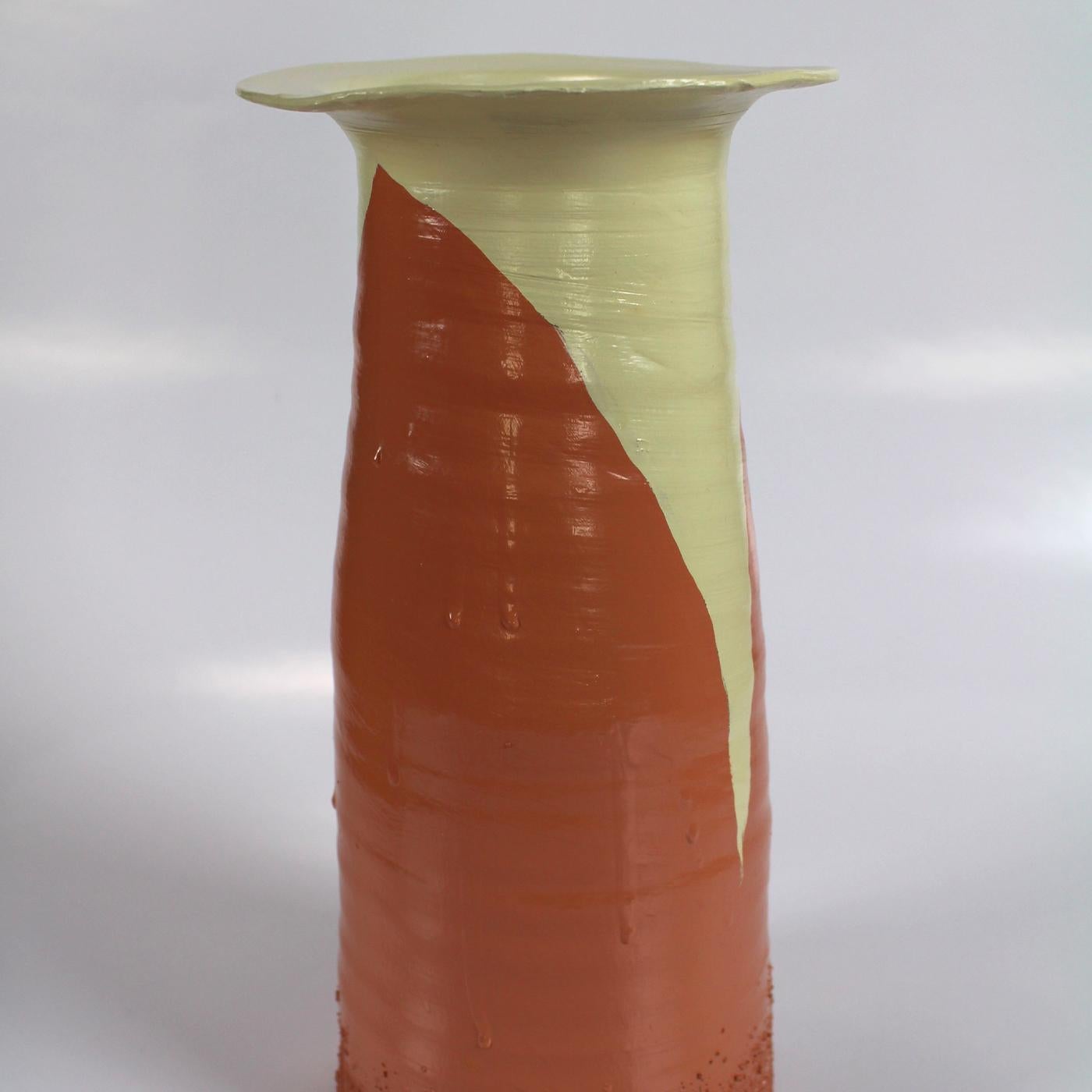 Imprégnant d'une élégance brute un intérieur moderne, ce vase fait partie d'une collection conçue par Mascia Meccani en 2019. Il est fait de terre cuite rouge avec une texture frappante qui orne son corps effilé avec une bouche évasée. Elle est