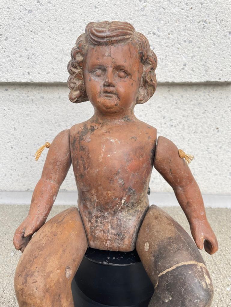 Amusing Mexican terracotta doll figure with articulated limbs. Since it is solid terracotta it is likely this is a mold from which other dolls were made. As a folk art sculpture it is absolutely charming. 
This one has a fun 'Marcel wave' hair