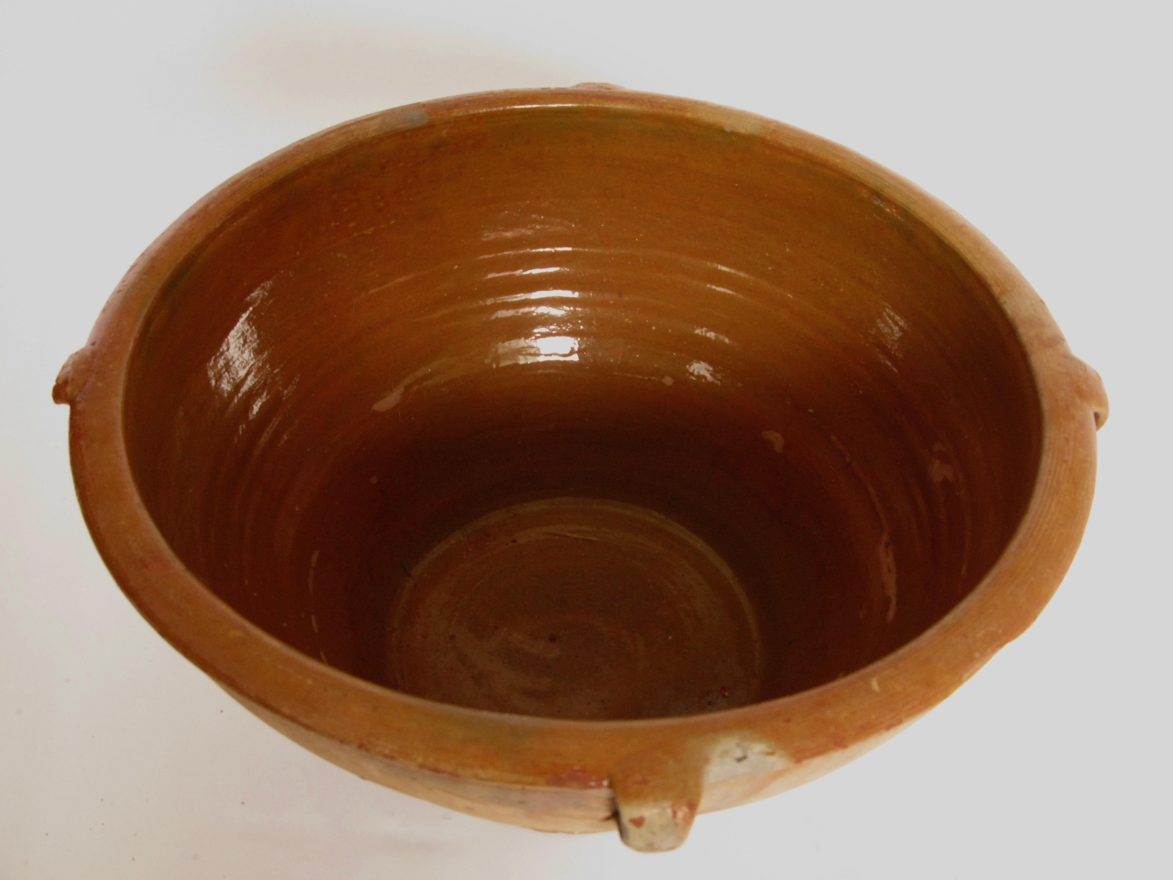 Lovely Spanish terracotta antique bowl with very small side handles,
one is damaged
It has a lovely patina and has lovely aged glaced colors, this is a very decorative piece for fruit, flowers, wine and or champagne cooler etc
origin: north of