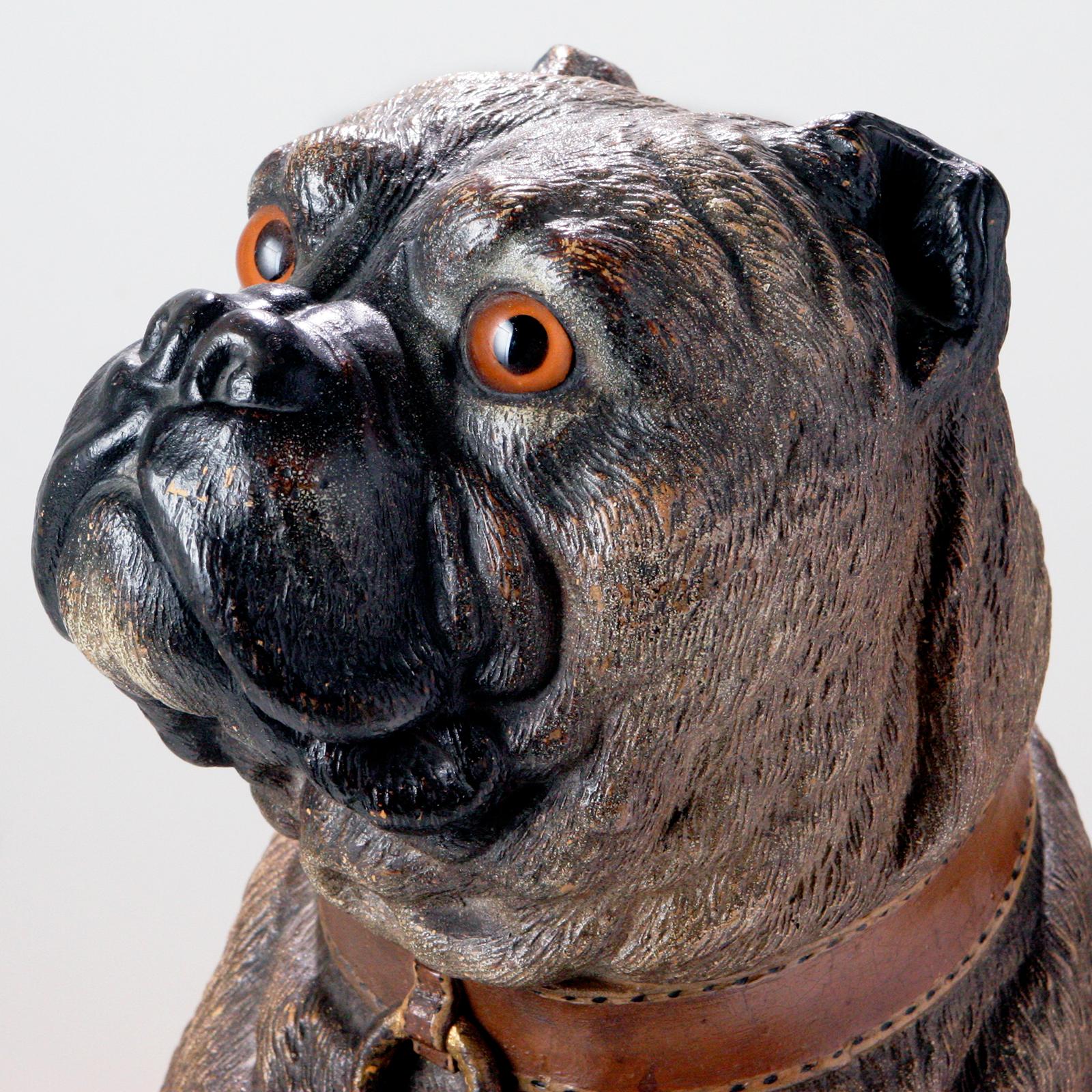 Raro bulldog inglés de terracota del siglo XIX, de tamaño natural. Con 21 pulgadas de altura, está sentado majestuosamente con la cabeza girada. He luce un amplio collar marrón con anilla. En el típico esmalte de cerámica marrón, pero en un tono