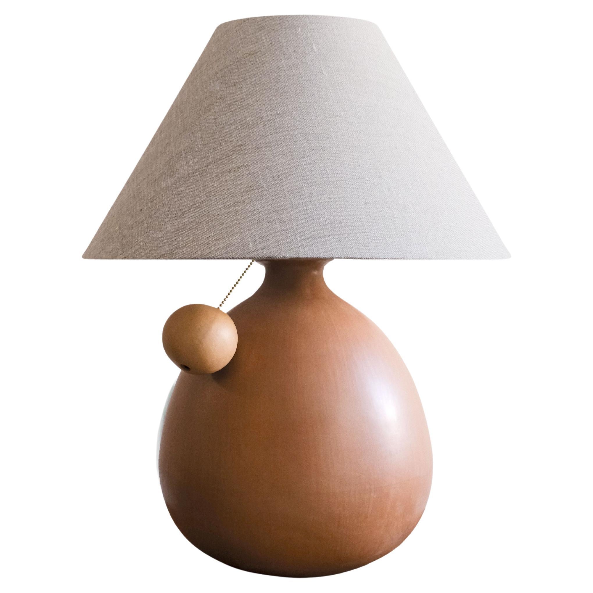 Lampada da tavolo in ceramica di terracotta  Paralume in lino color avena e tirante a sfera, Barro Bruñido