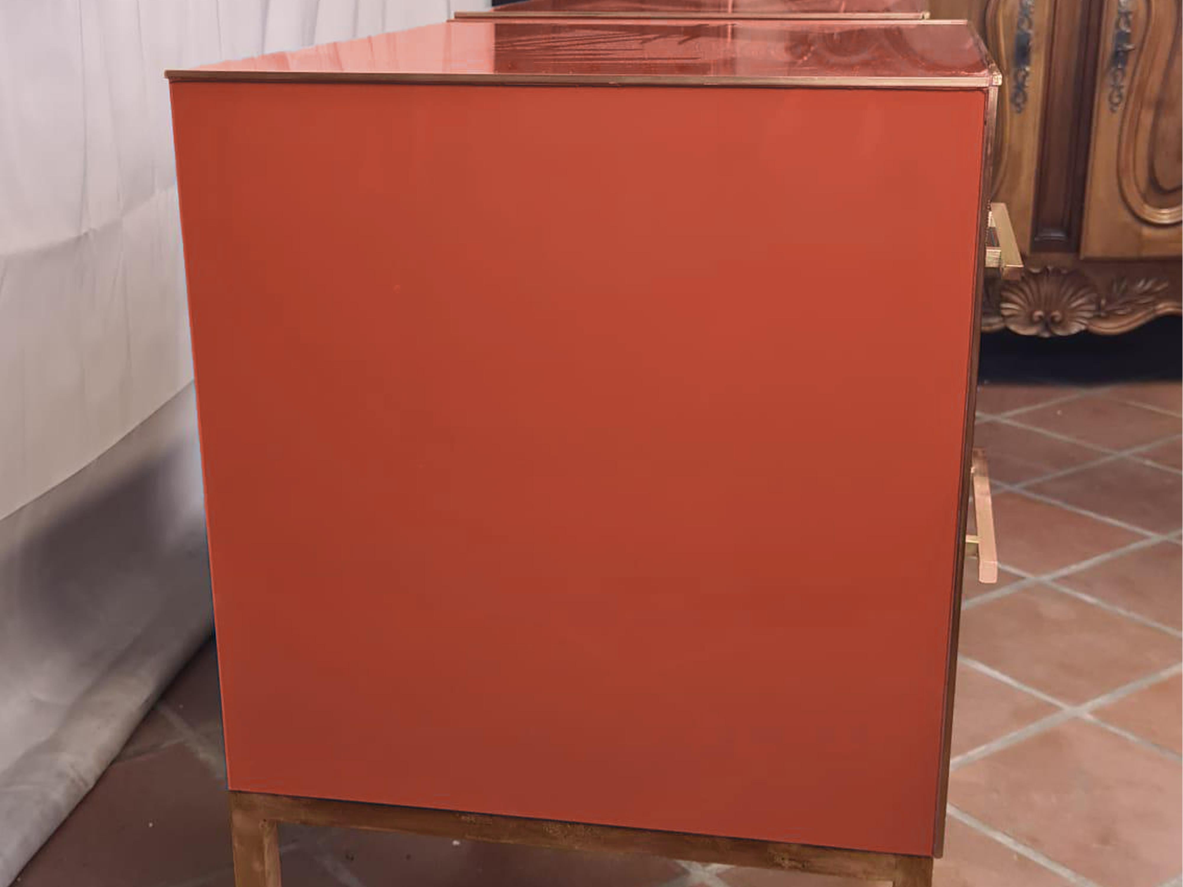Embellish your bedroom with these exquisite Italian bedside tables, featuring terracotta-colored Murano glass tops and drawers. 

Handcrafted by skilled artisans, these mid-century modern pieces combine birch wood frames with polished brass accents