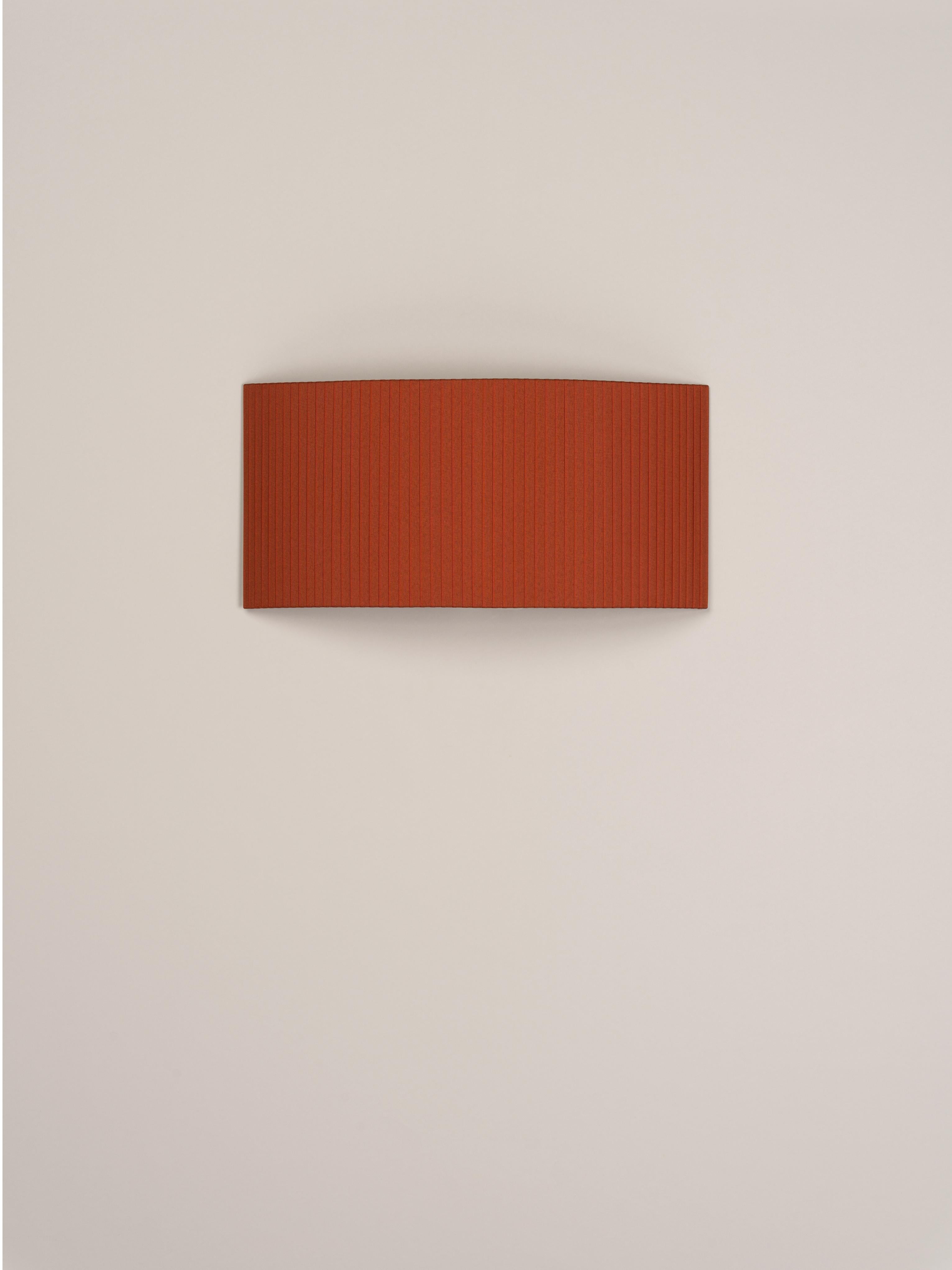 Terracotta Comodín rectangular wall lamp by Santa & Cole.
Dimensions: D 50 x W 13 x H 24 cm.
Materials: Metal, ribbon.

This minimalist wall lamp humanises neutral spaces with its colourful and functional sobriety. The shade is fondly