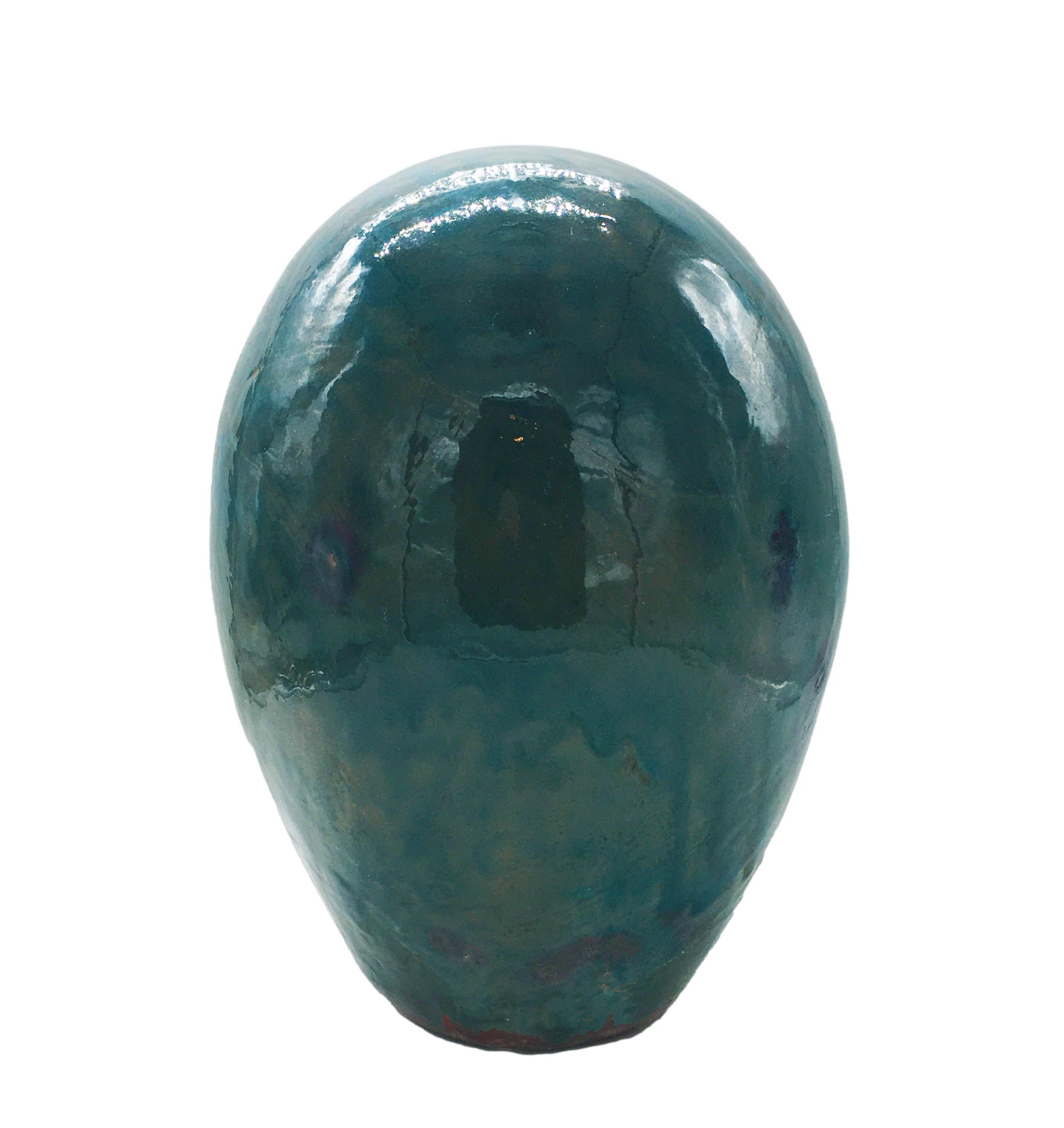 Original and emblematic sculpture in green glazed terracotta of oval shape, Made in Italy 1960.