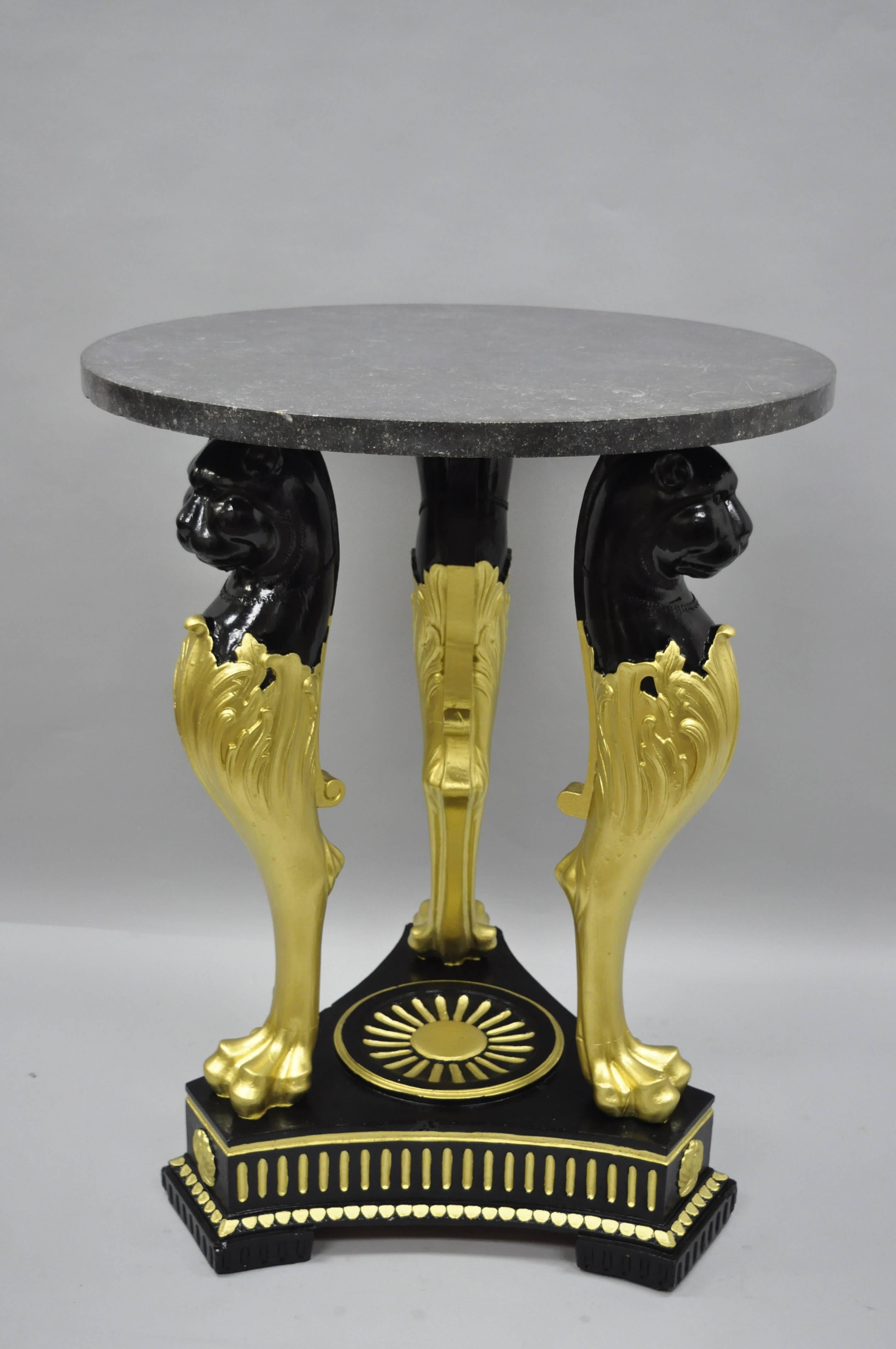 Large pair of terracotta French Empire style black and gold figural tables with round granite tops. Item features very impressive triple lion, paw foot, solid terracotta bases, black and gold painted finish, and round granite stone tops. Tables