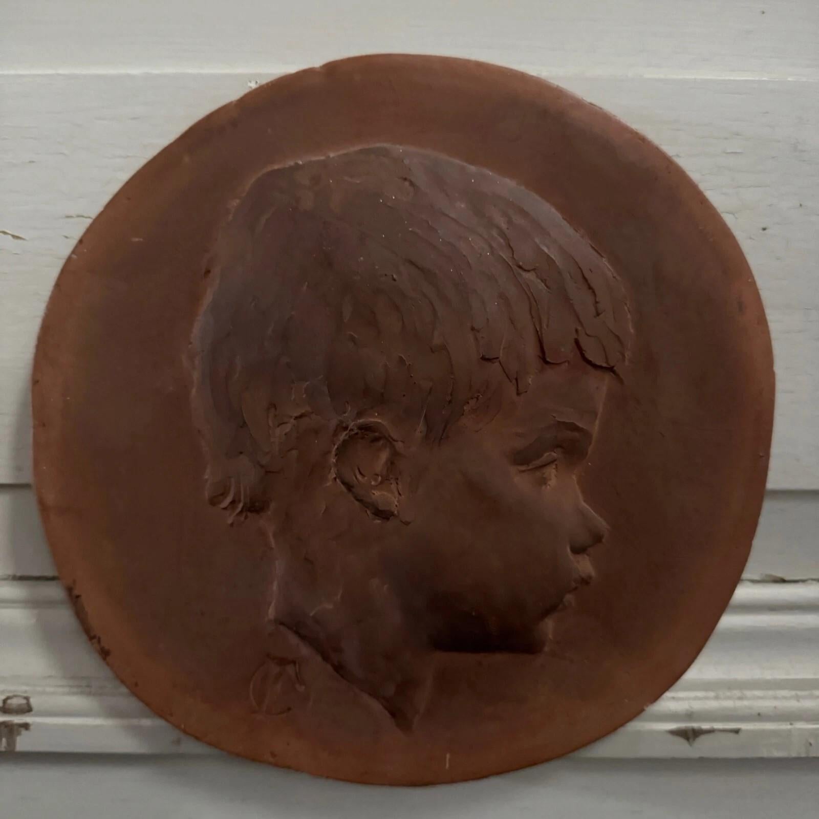 Sculpté à la main Terracotta medallion by Charles Filleul – Profile of a young child, 20th century en vente