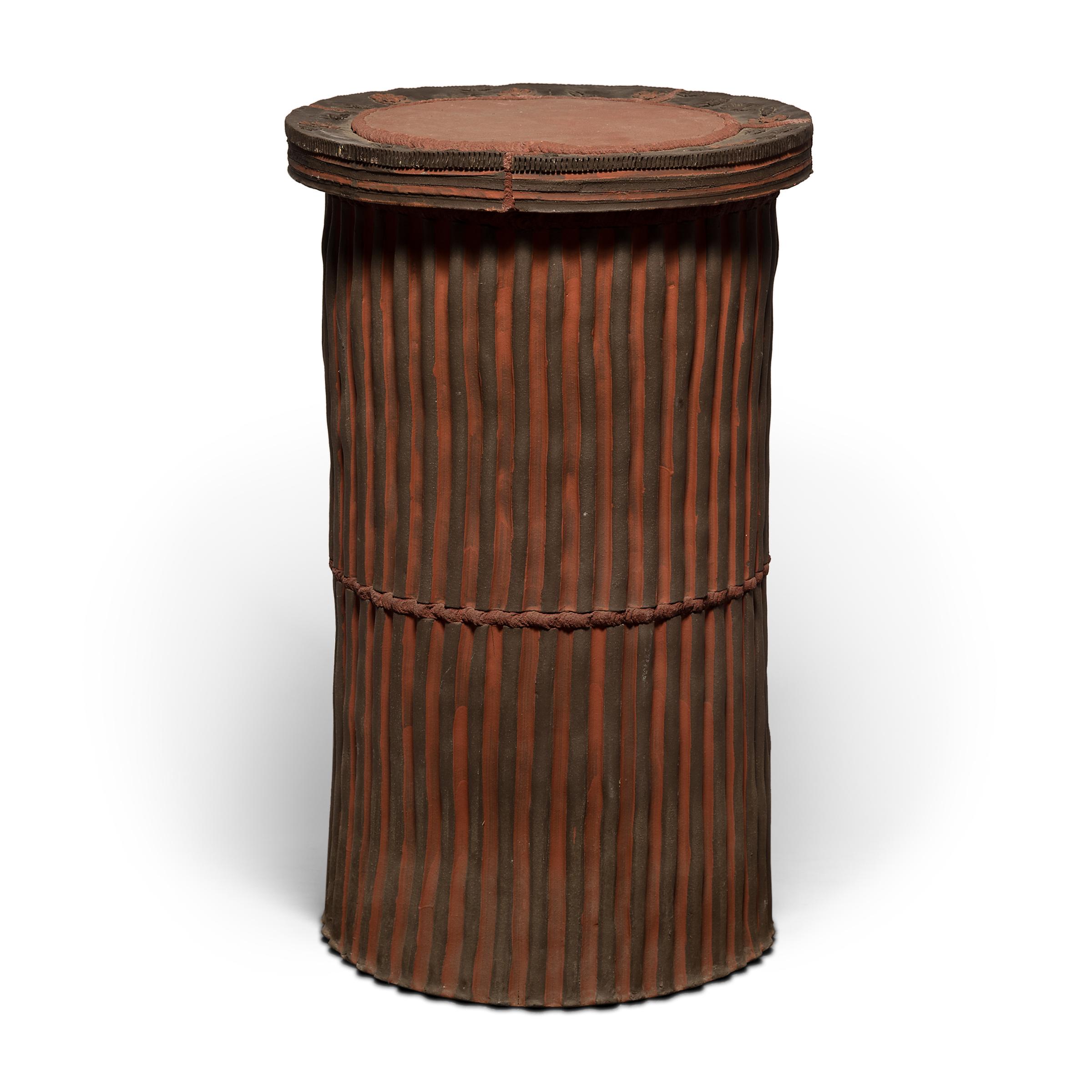 Both a functional piece of furniture and an intriguing sculpture, this ceramic pedestal is a statement-making centerpiece in any room. Mixing terracotta and ebony hues, the pedestal is carefully constructed of ropes, slabs, and smears of clay. The