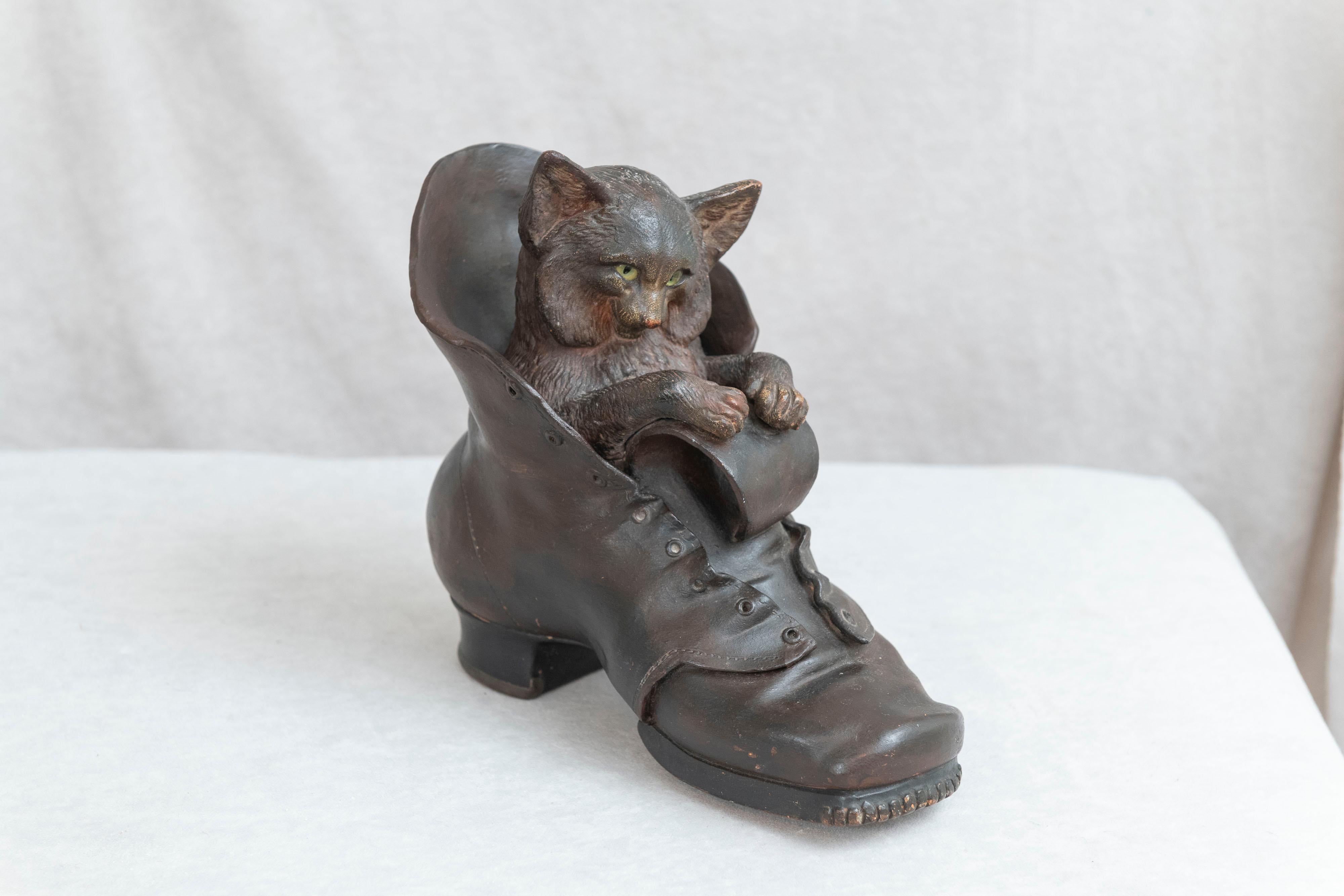 Terracotta is one of our favorite mediums. This whimsical piece of sculpture explains why we do search it out. The cat with these original glass eyes has a look that only a feline can exhibit, and the old shoe looks so real it could pass for
