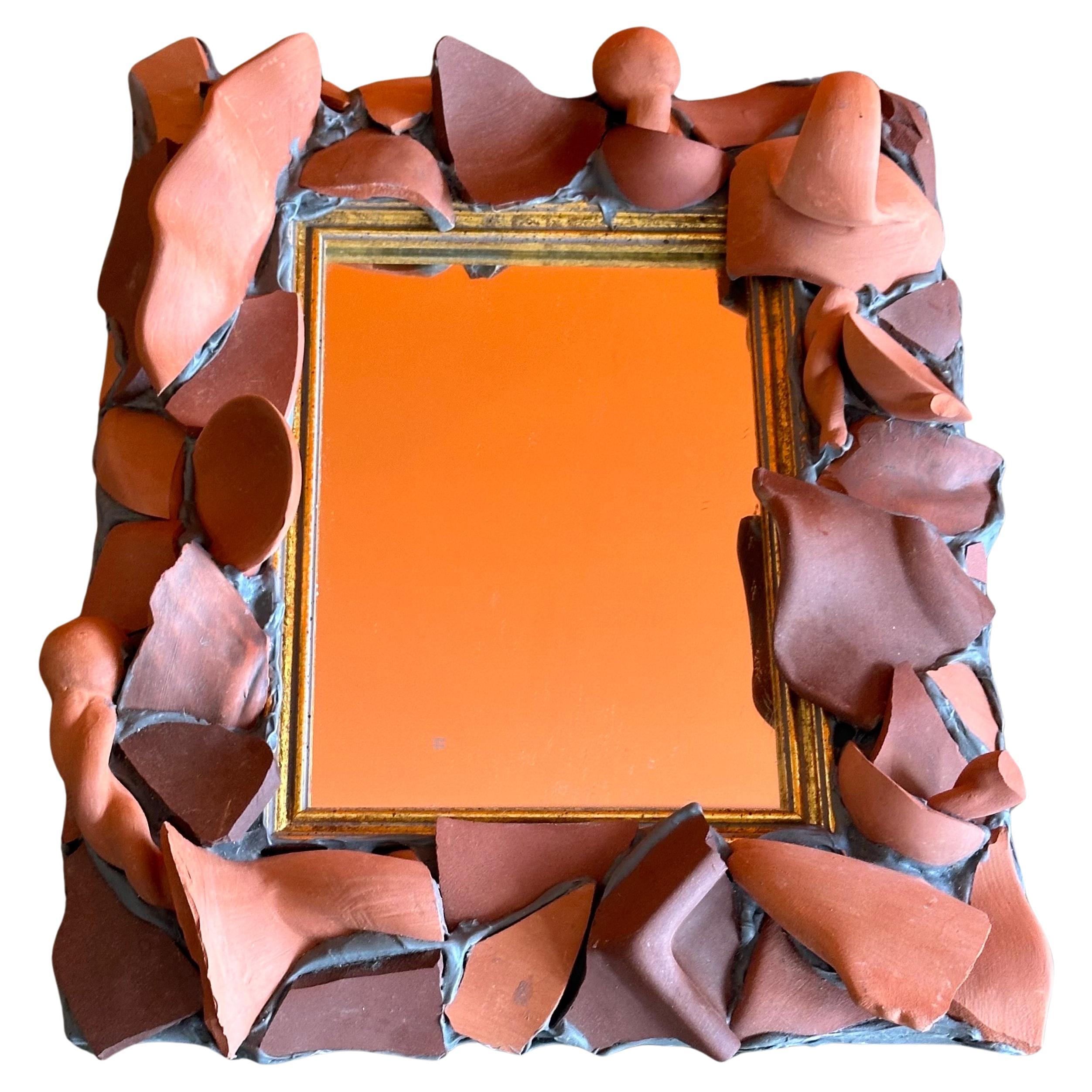 A super cool and incredibly hard to find terracotta pottery shards table mirror or picture frame by MacKenzie Childs, circa 1990s. The piece is in very good condition and measures 9.25