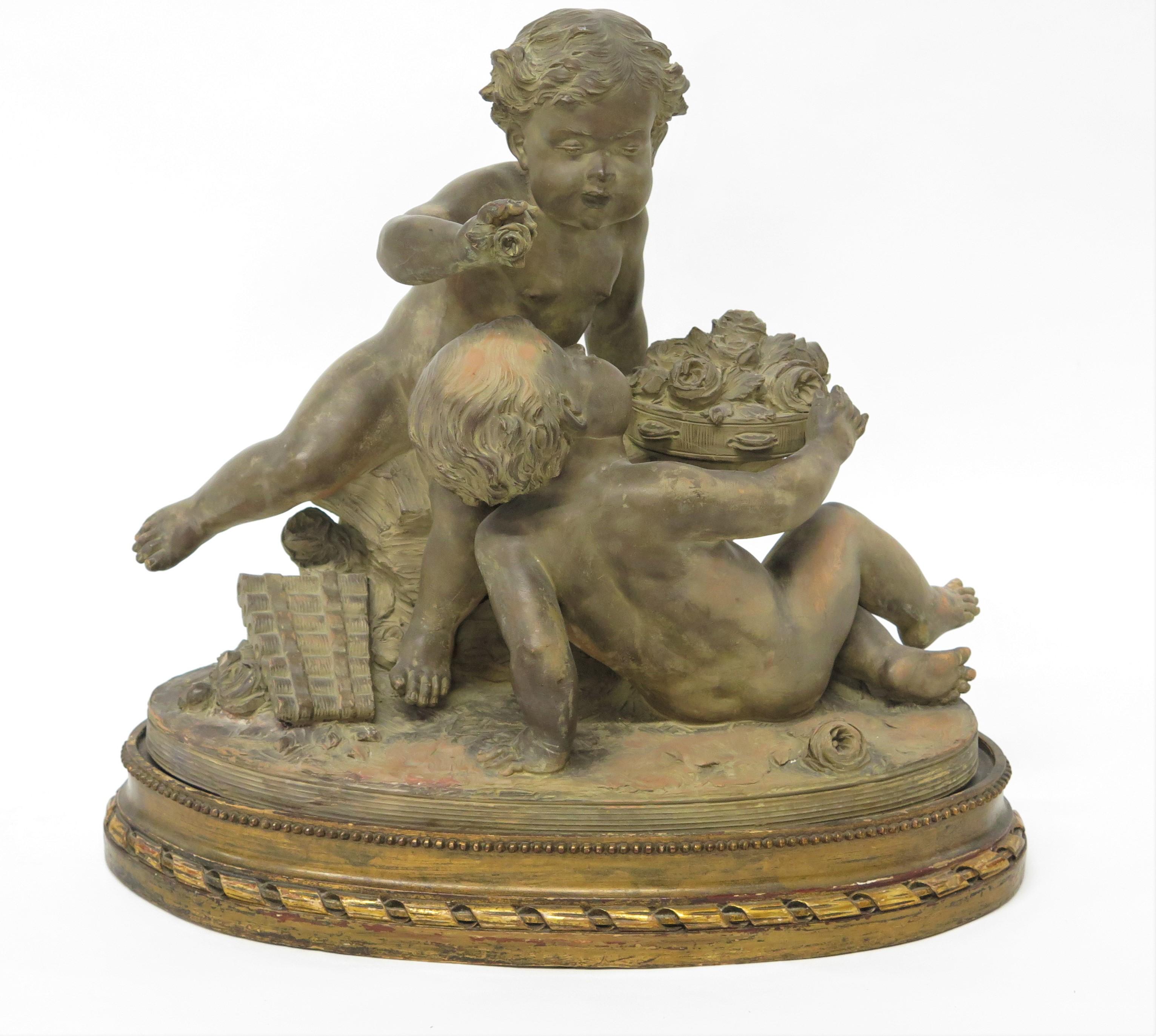 Estatua Putti de terracota que descansa sobre una base ovalada elevada y conforme Firmada 