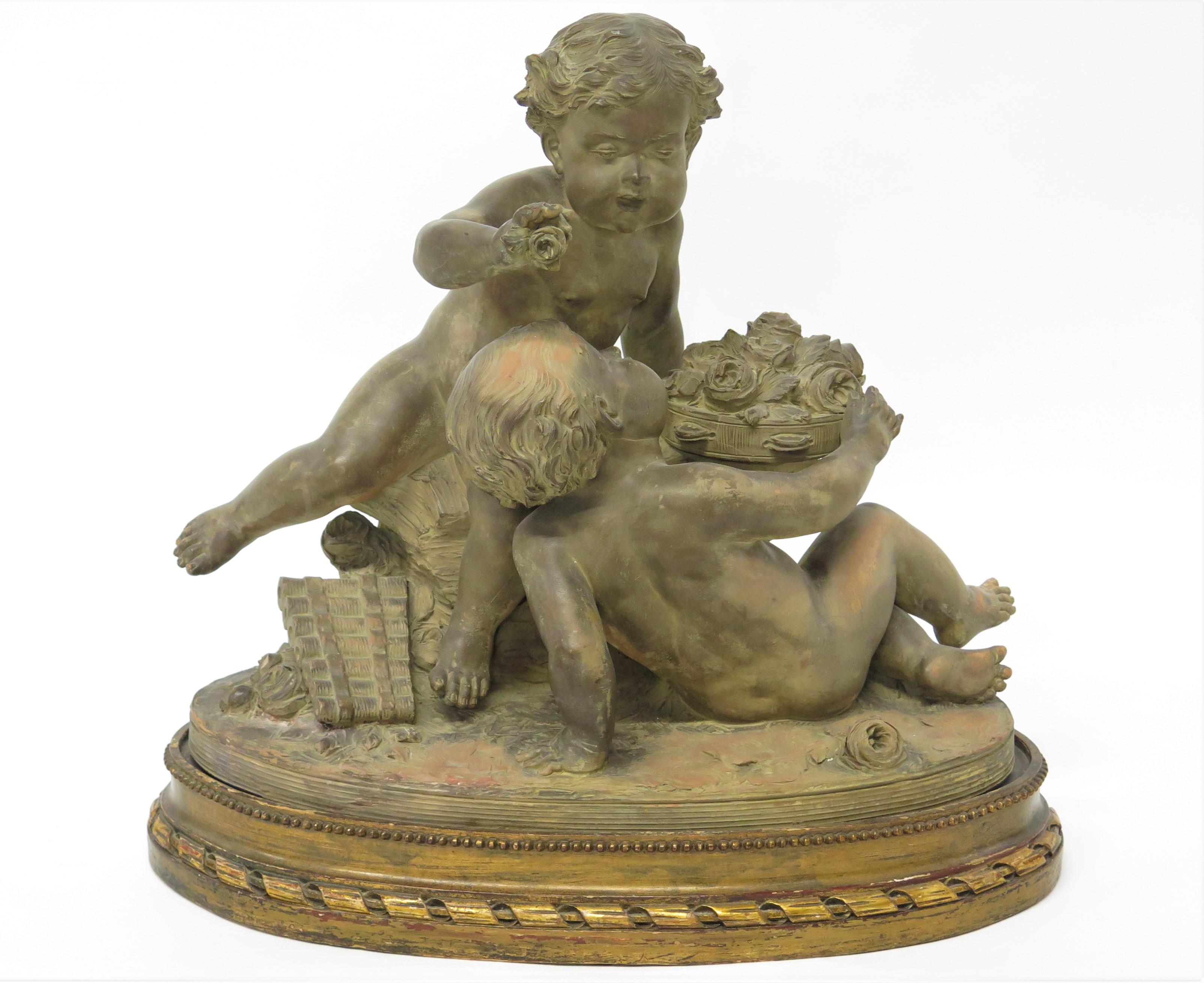 Estatua Putti de terracota apoyada en una base ovalada elevada firmada 