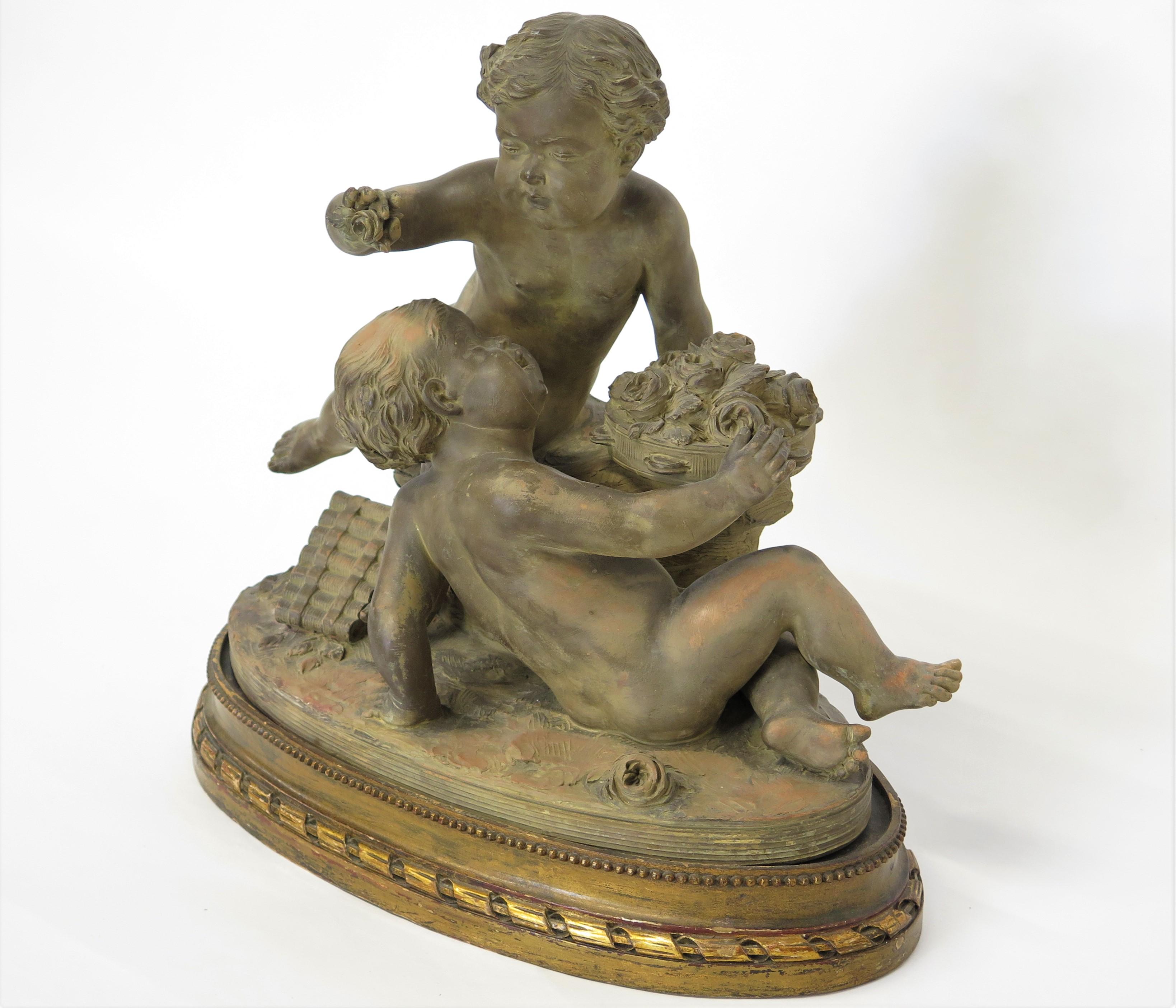 Estatua Putti de terracota que descansa sobre una base ovalada elevada y conforme Firmada 