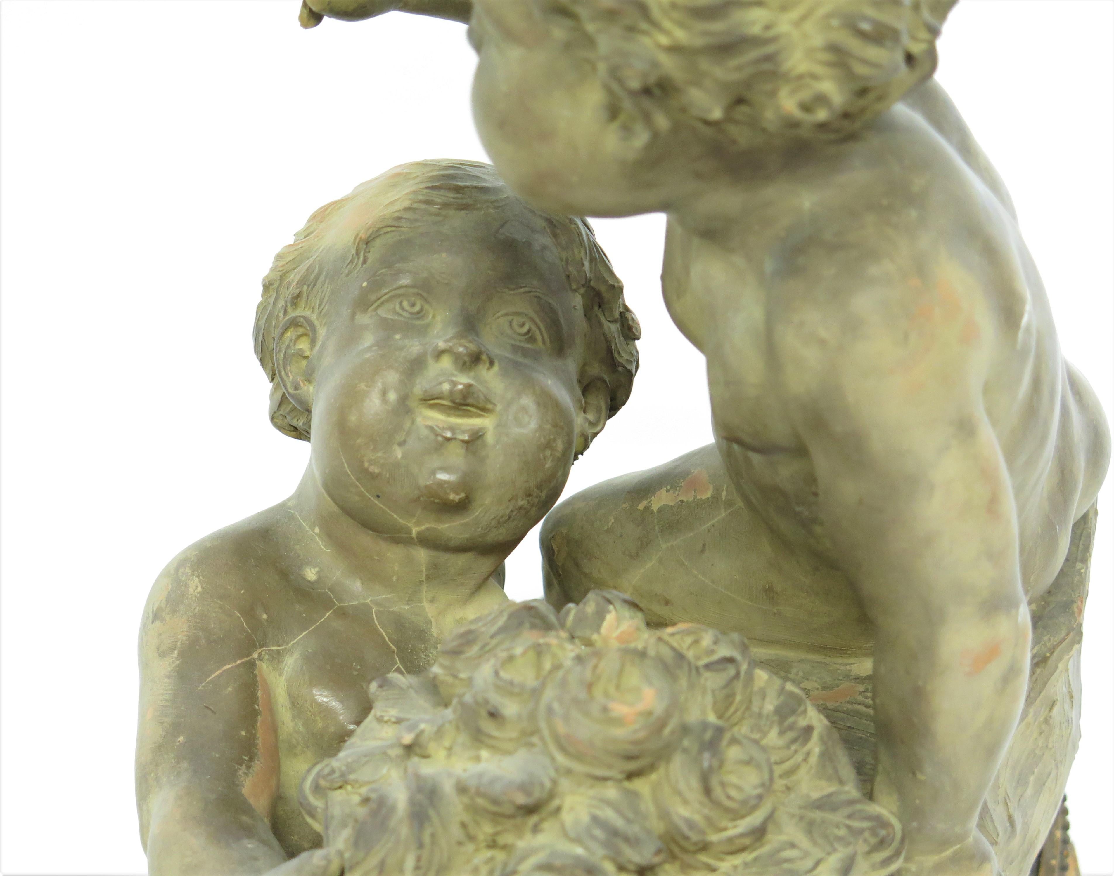 Estatua Putti de terracota que descansa sobre una base ovalada elevada y conforme Firmada 