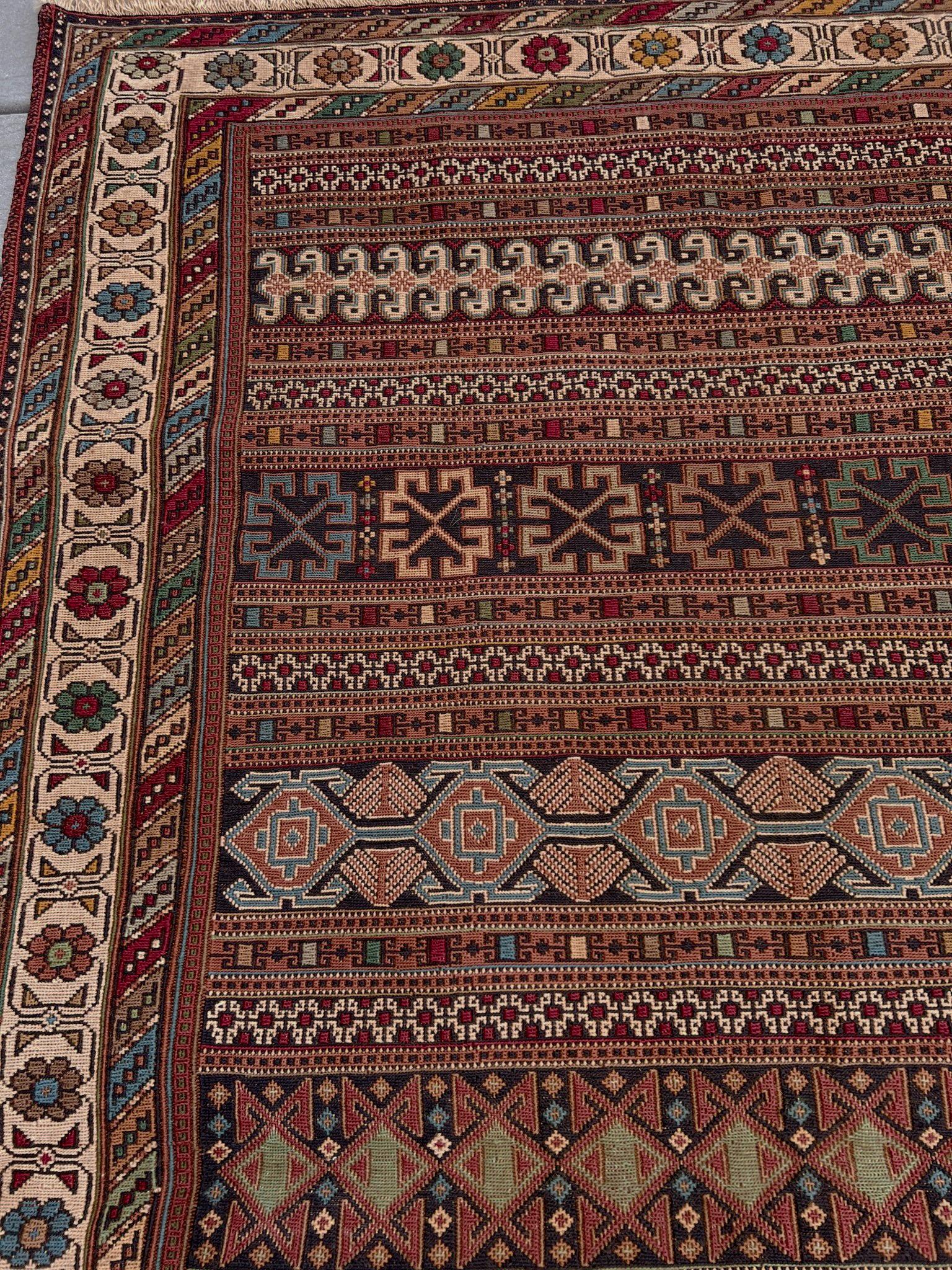 Esta alfombra Soumak Shahsavan vintage del noroeste de Irán es una obra maestra de geometría tribal y equilibrio cromático. Tejido a mano en la década de 1960 con lana hilada a mano y teñida con raíces y plantas, muestra el clásico dibujo de