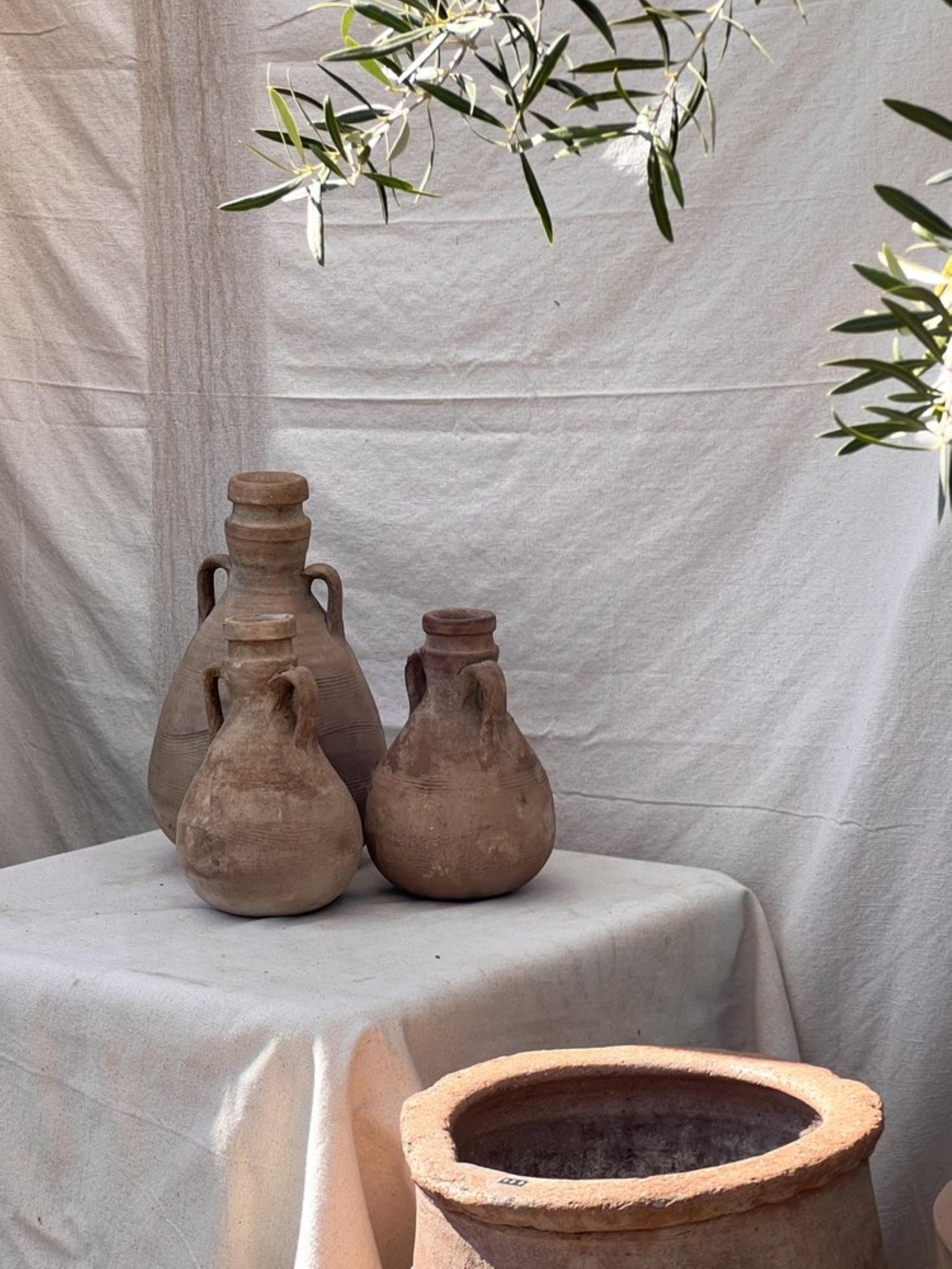 Our Terracotta Roman Pottery Set with Our Captivating Sphere-Shaped Wine Amphorae. Each Amphora is Meticulously Crafted with Two Handles, a Flattened Base, and Adorned with Enchanting Spiral-Shaped Random Pottery Markings on the Surface. Dating Back